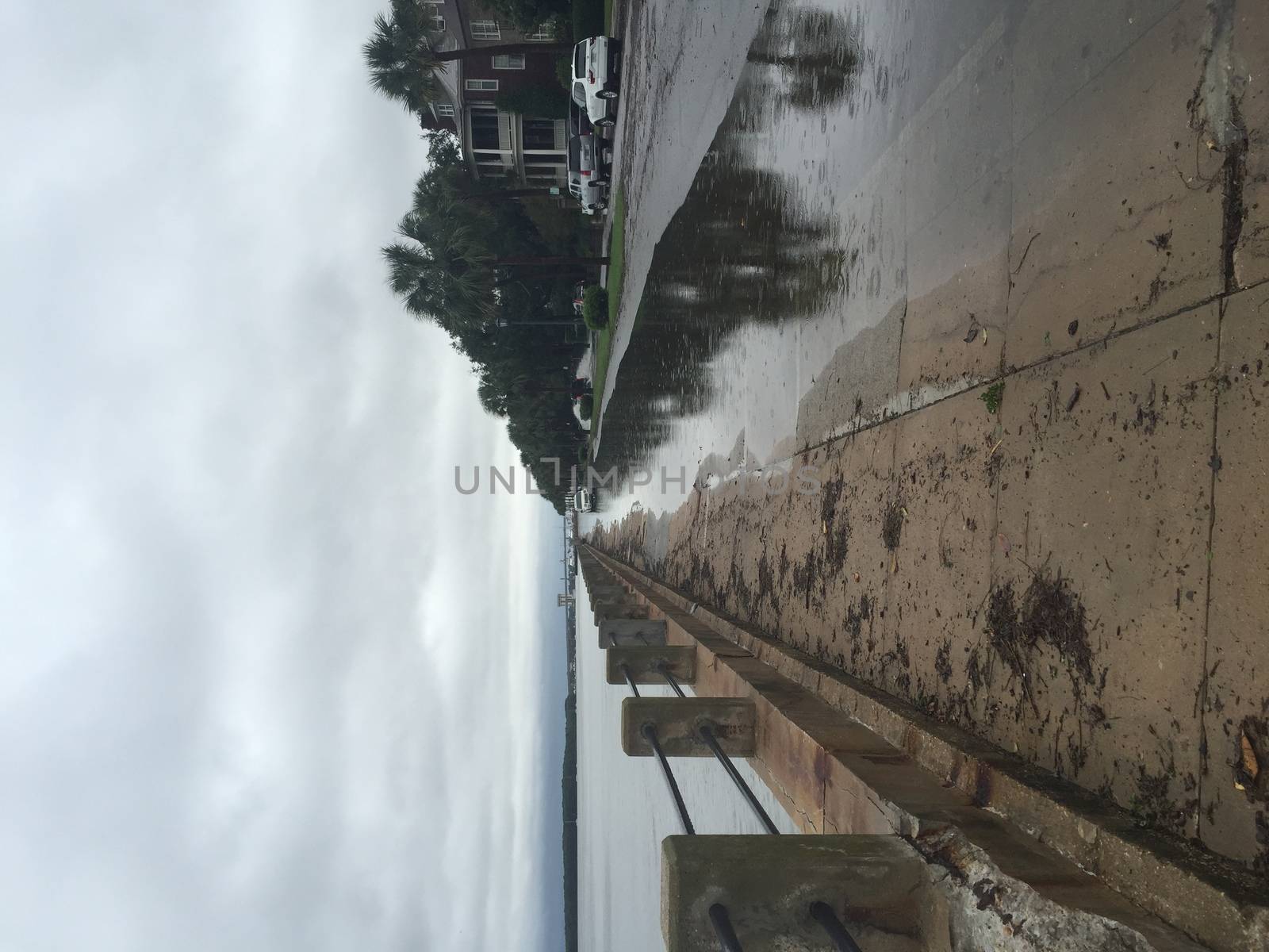 UNITED-STATES, Charleston : A rain water puddle overflows a road when catastrophic floods ravaged much of South Carolina on October 4, 2015. Heavy rains dropped nearly 17 inches on the state capital of Charleston in a 17 hour span. At least nine people died in South Carolina as a result of the flooding and one person has died in neighboring North Carolina. The storms also left some 30,000 residents without power and shut down many major roads. Governor Nikki Haley called the rains the worst in 1,000 years. 