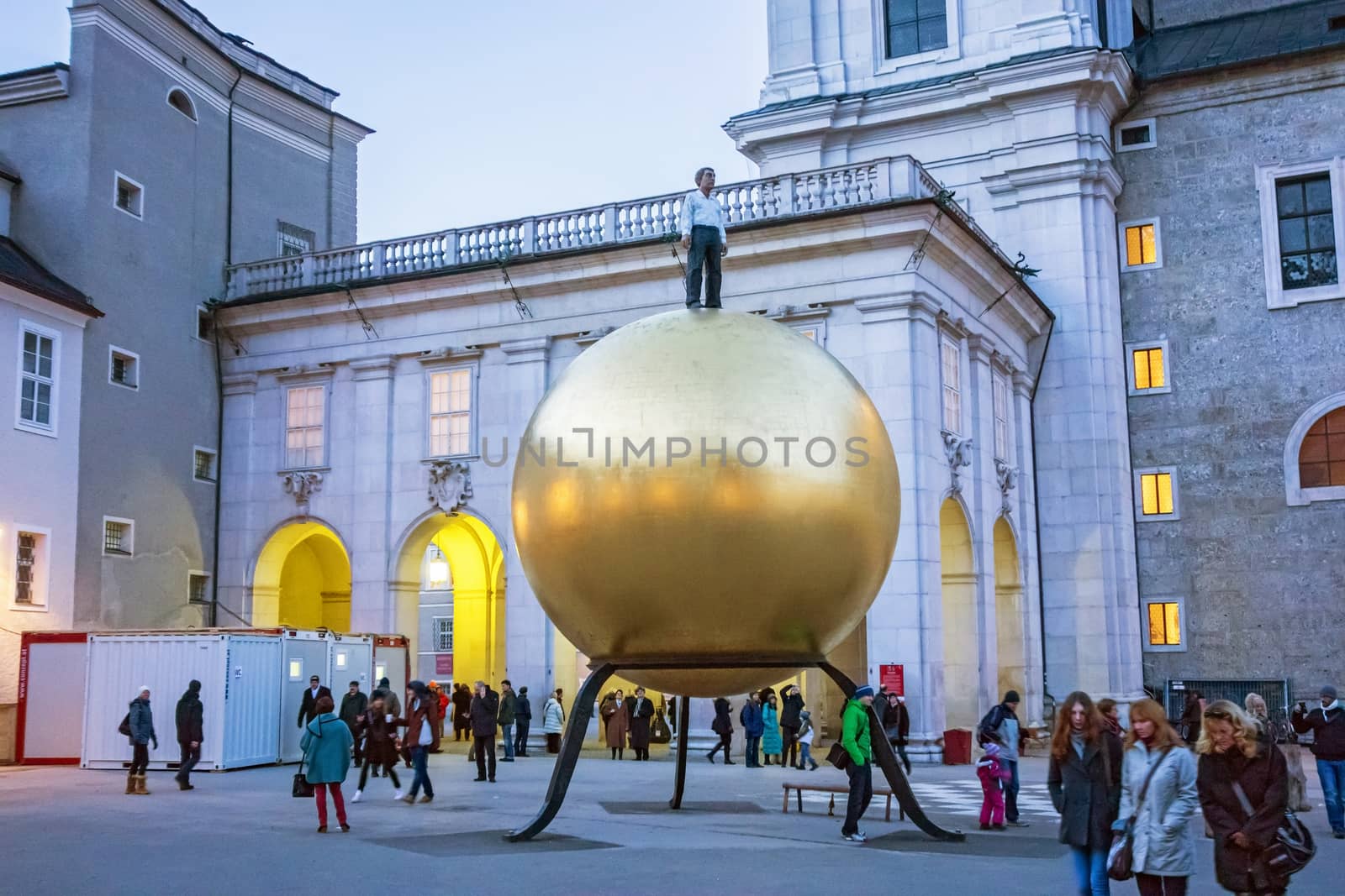 Salzburg, Austria - December 31, 2013: Golden sphere with man standing on it at Kapitelplatz at night - near the Cathedral of Salzburg.