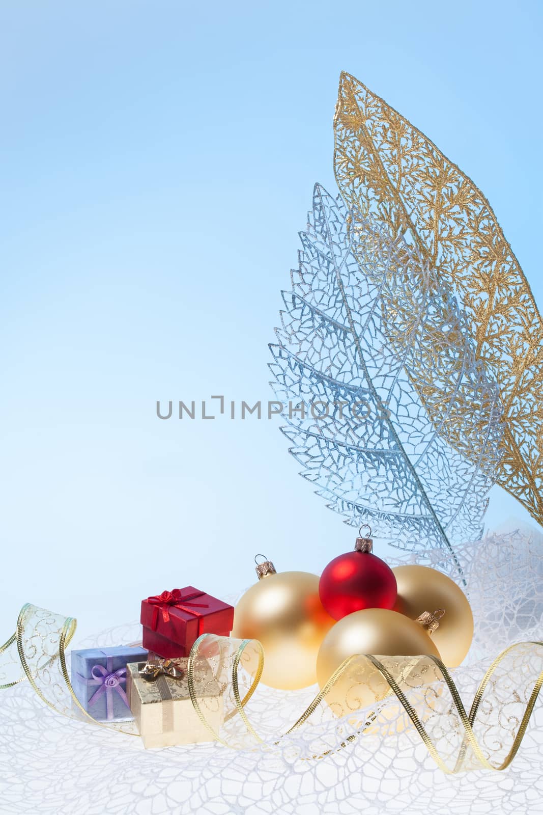 New Year background with golden glass toys and little presents with decorative leafs