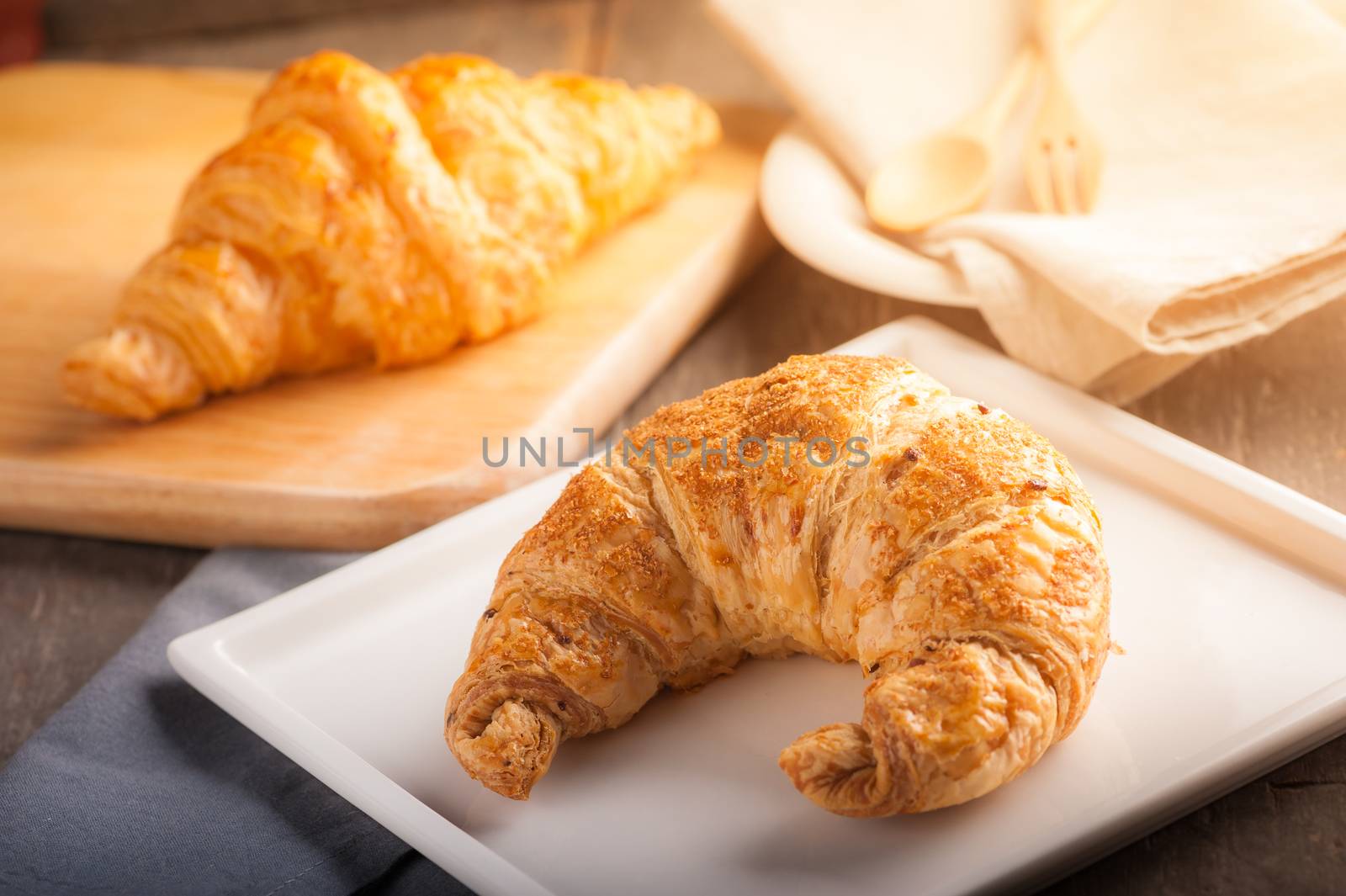 Whole wheat croissant on ceramic dish with morning scene