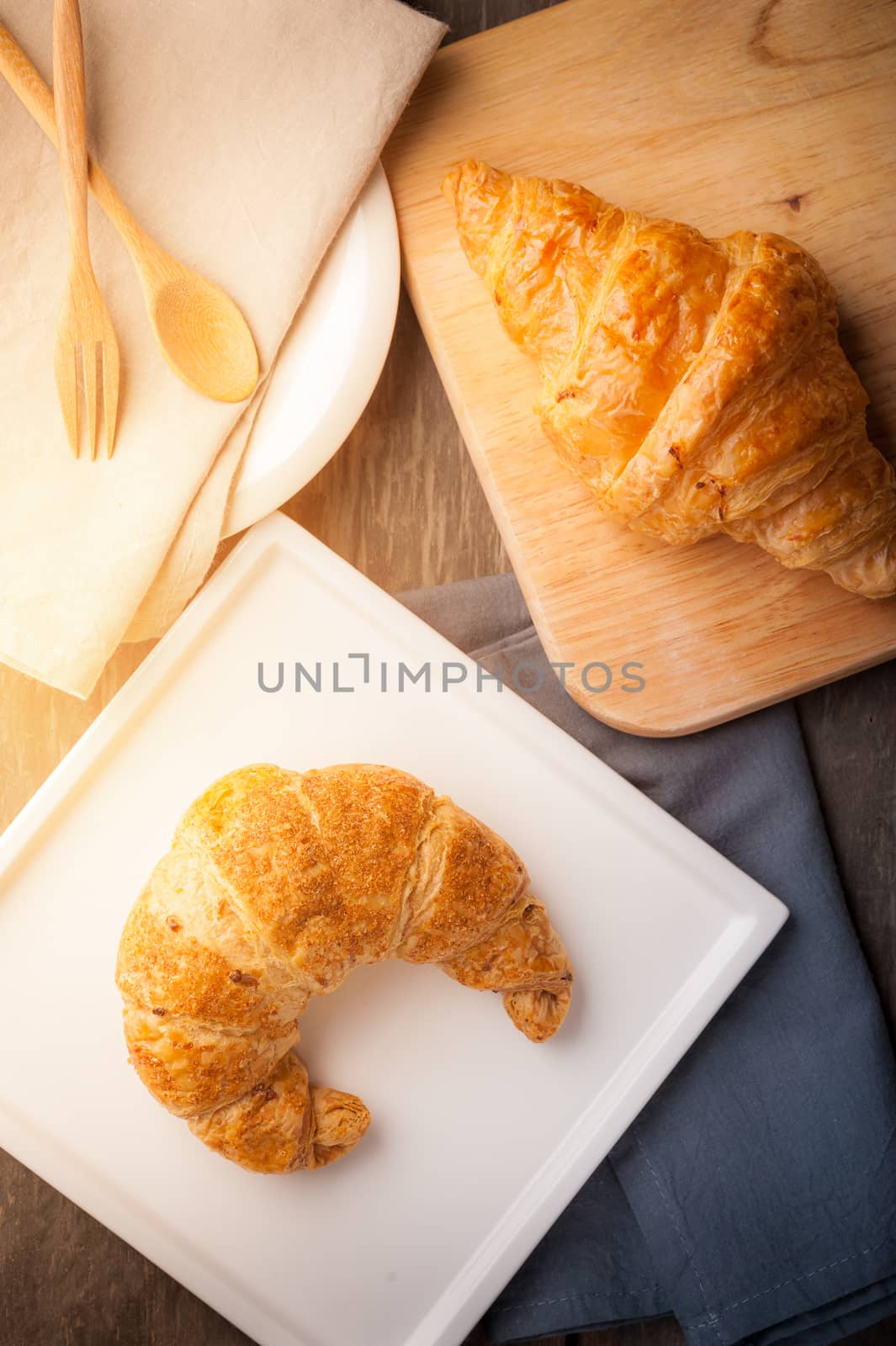 Whole wheat croissant on ceramic dish with morning scene