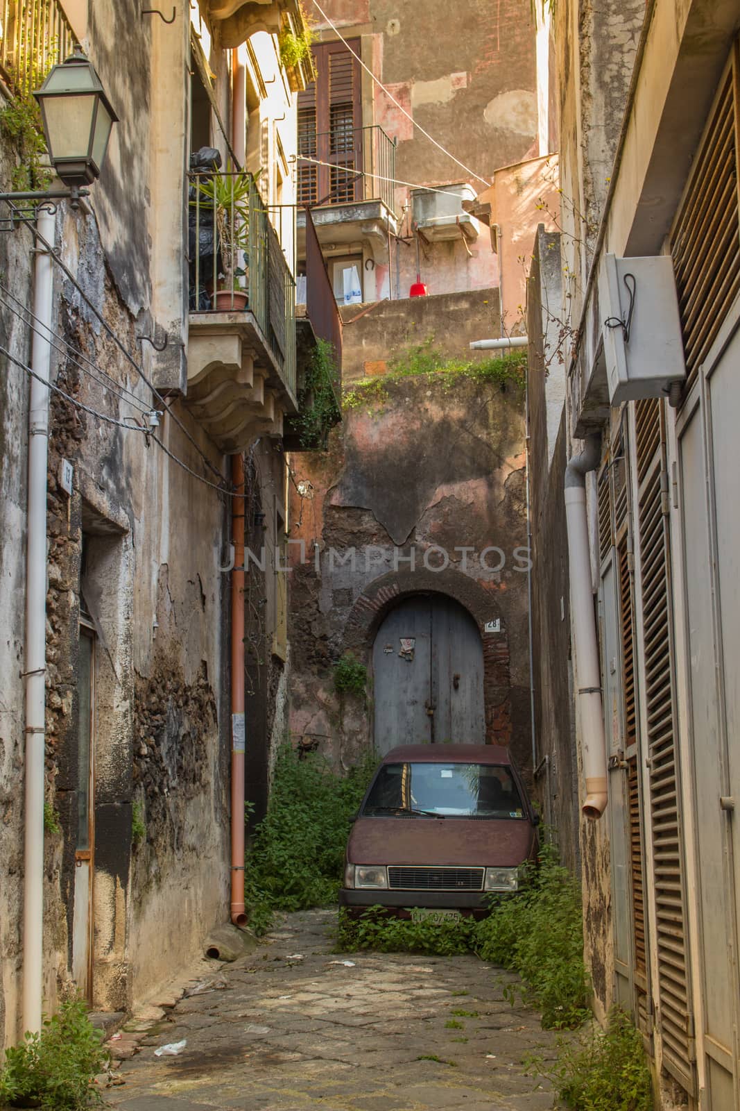 The old streets of acireale with a lonely car, catania, sicily.