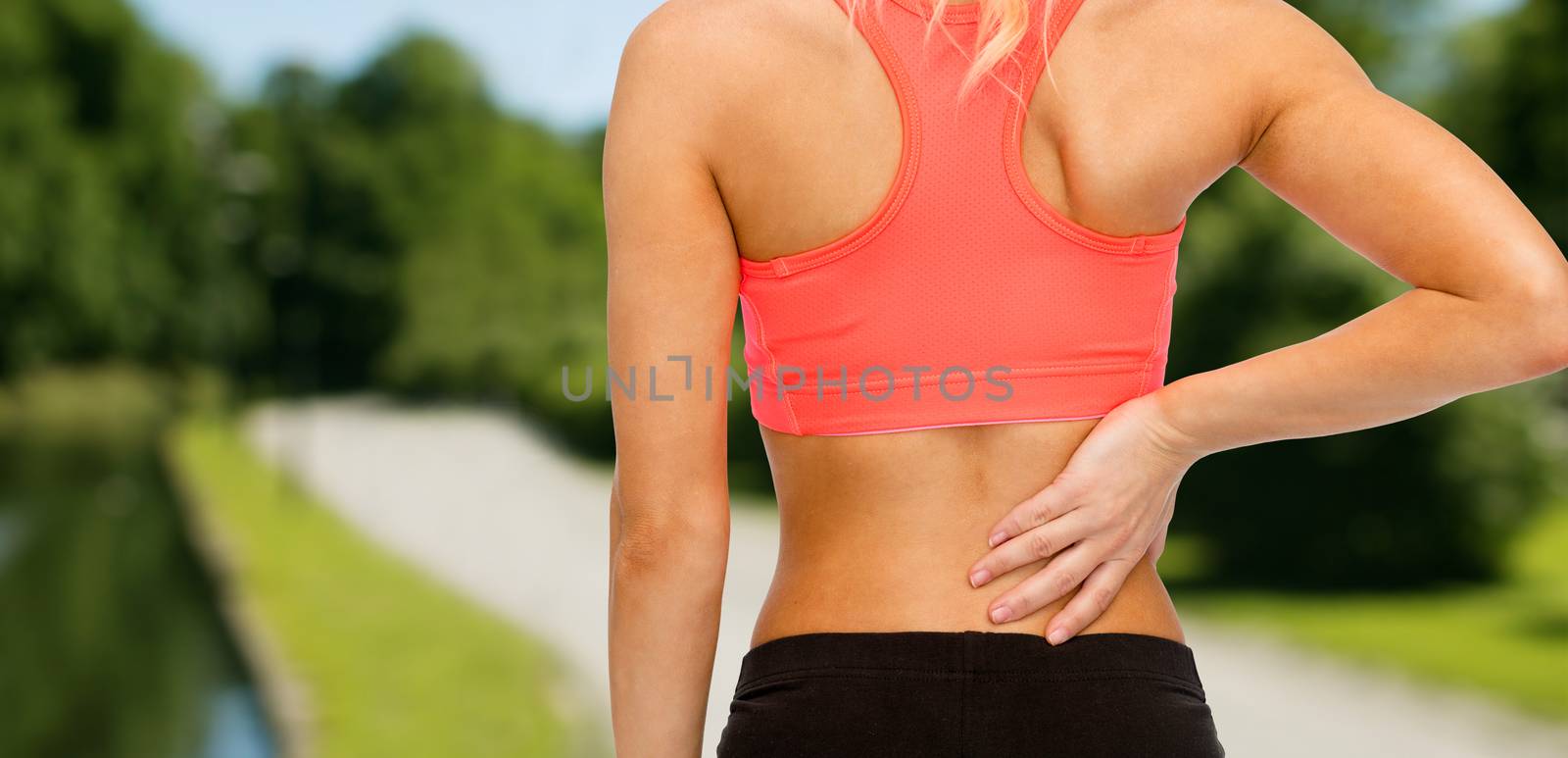 close up of sporty woman touching her back by dolgachov