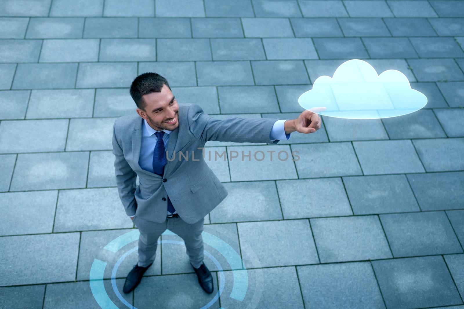 business, development, technology and people and concept - young smiling businessman pointing finger to cloud projection outdoors from top