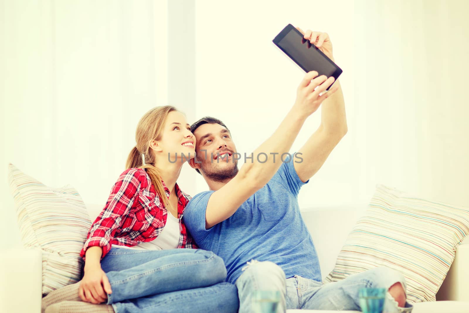 home, technology and relationships concept - smiling couple with tablet pc computer at home