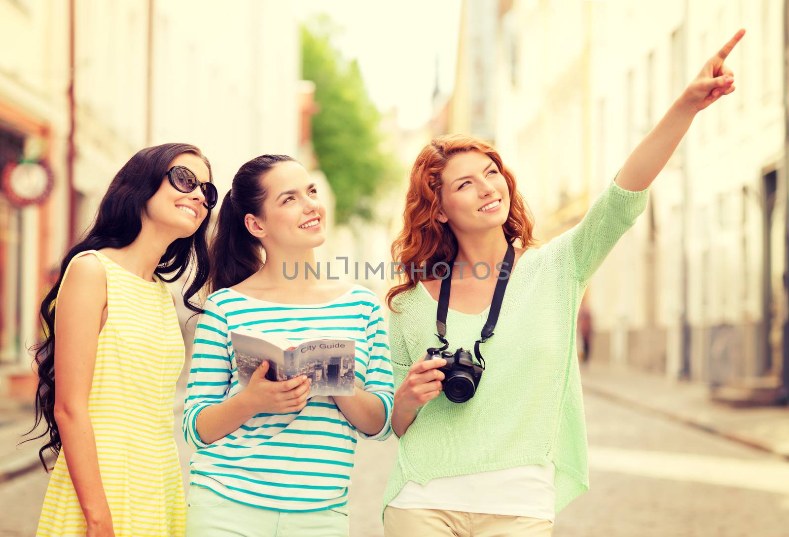 smiling teenage girls with city guide and camera by dolgachov