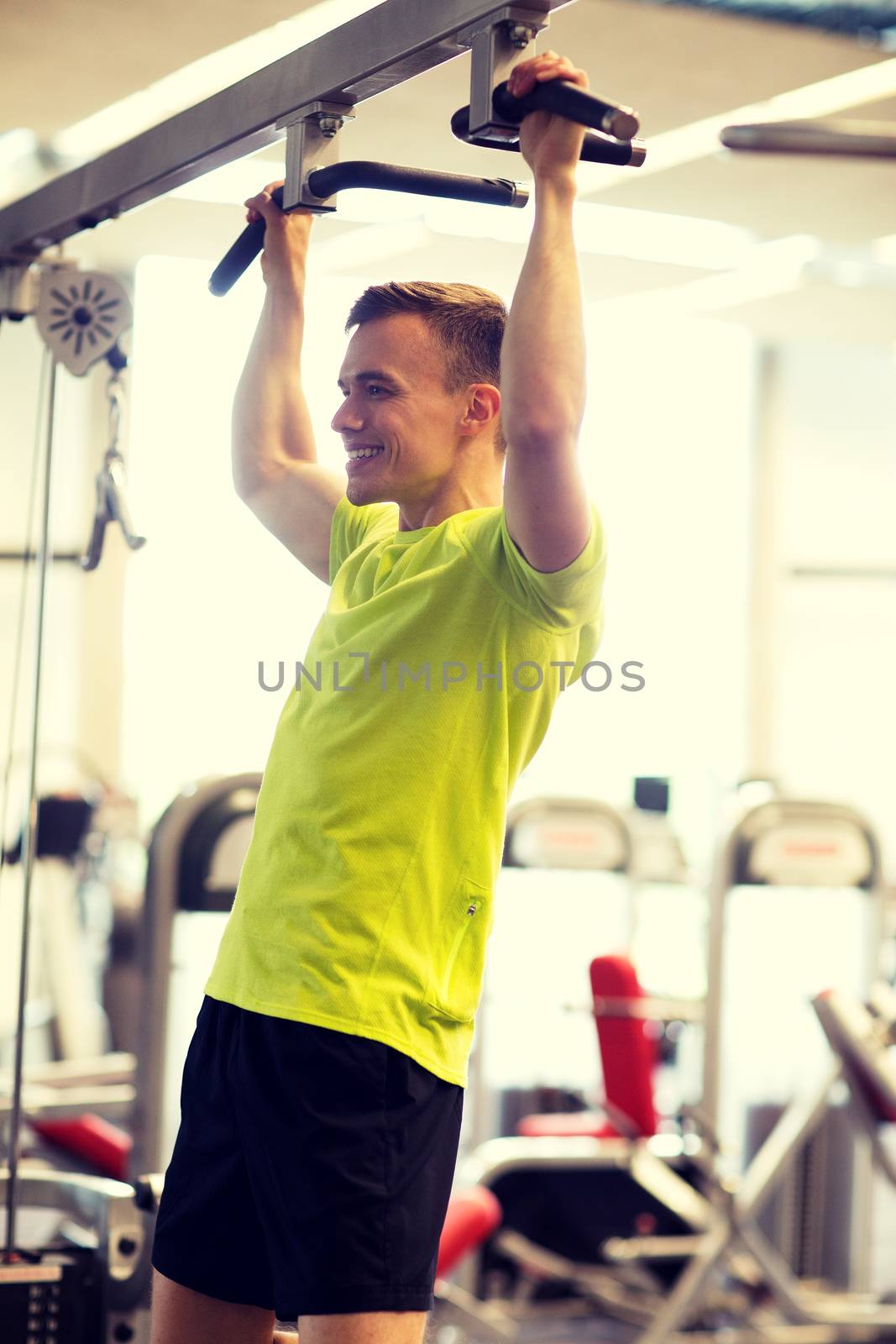 smiling man exercising in gym by dolgachov