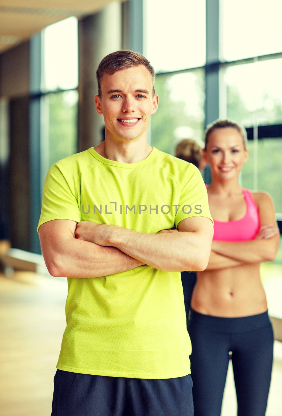 sport, fitness, lifestyle and people concept - smiling man and woman in gym