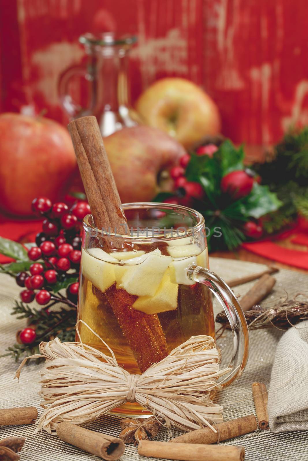 Sparkling Apple Cider with cinnamon and an apple slice on wooden table, festive decoration