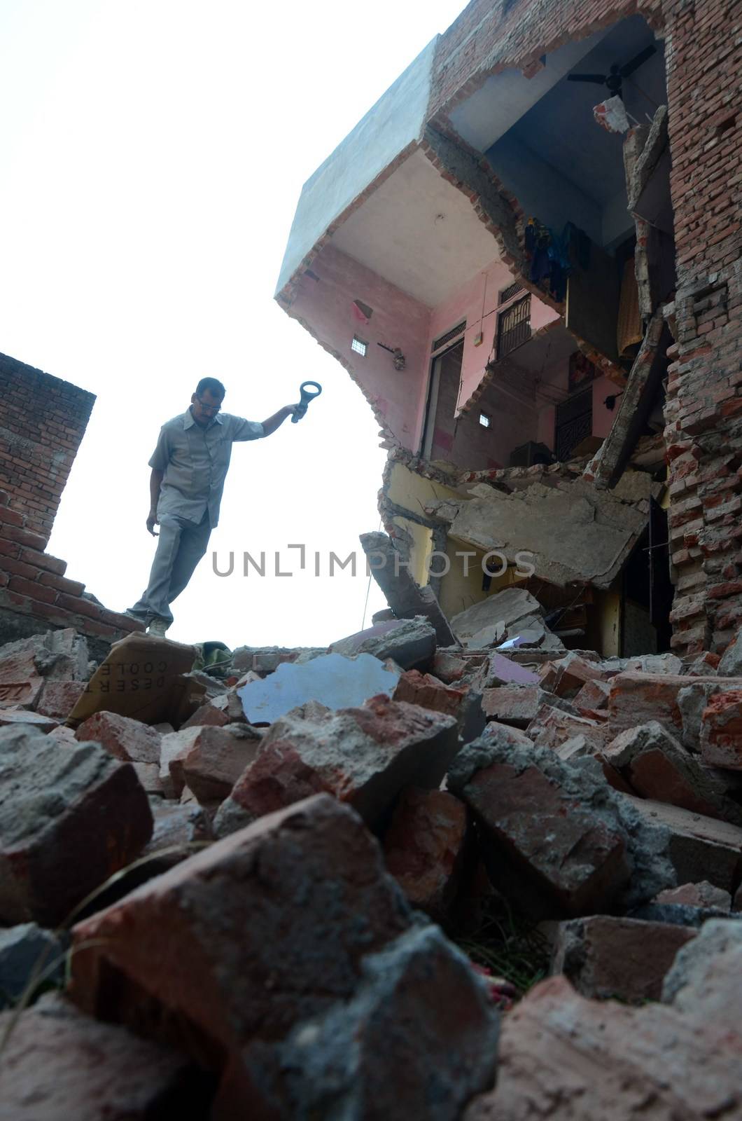 INDIA, Allahabad: A member of bomb disposal squad inspecting the aftermath of an explosion on October 6, 2015, the blast caused two houses to collapse, killing two people and critically injuring three others.  According to our contributor on the ground, the firecracker factory was operating illegally.