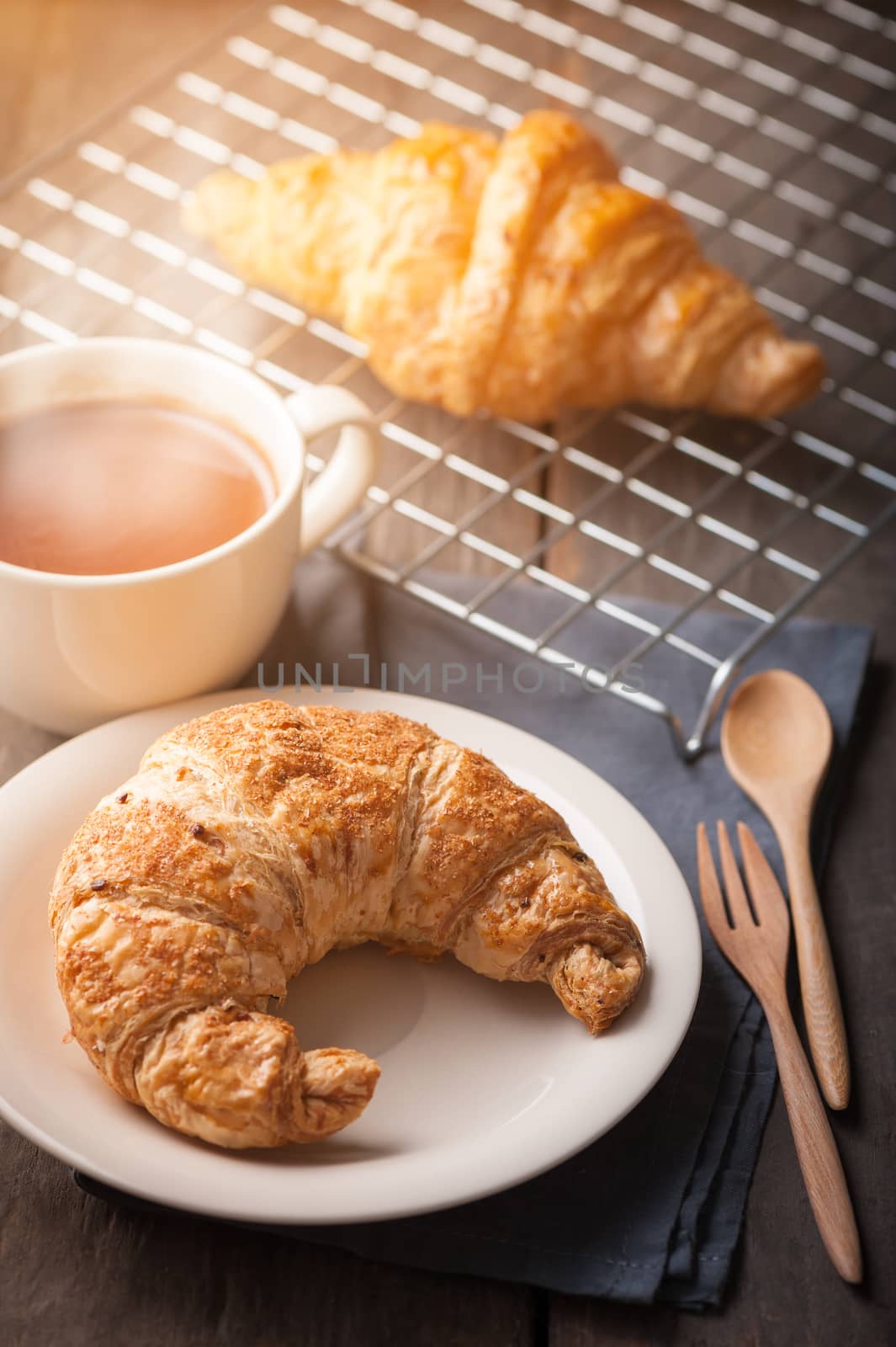Butter croissant and whole wheat croissant with a cup of hot chocolate on wood table with morning scene