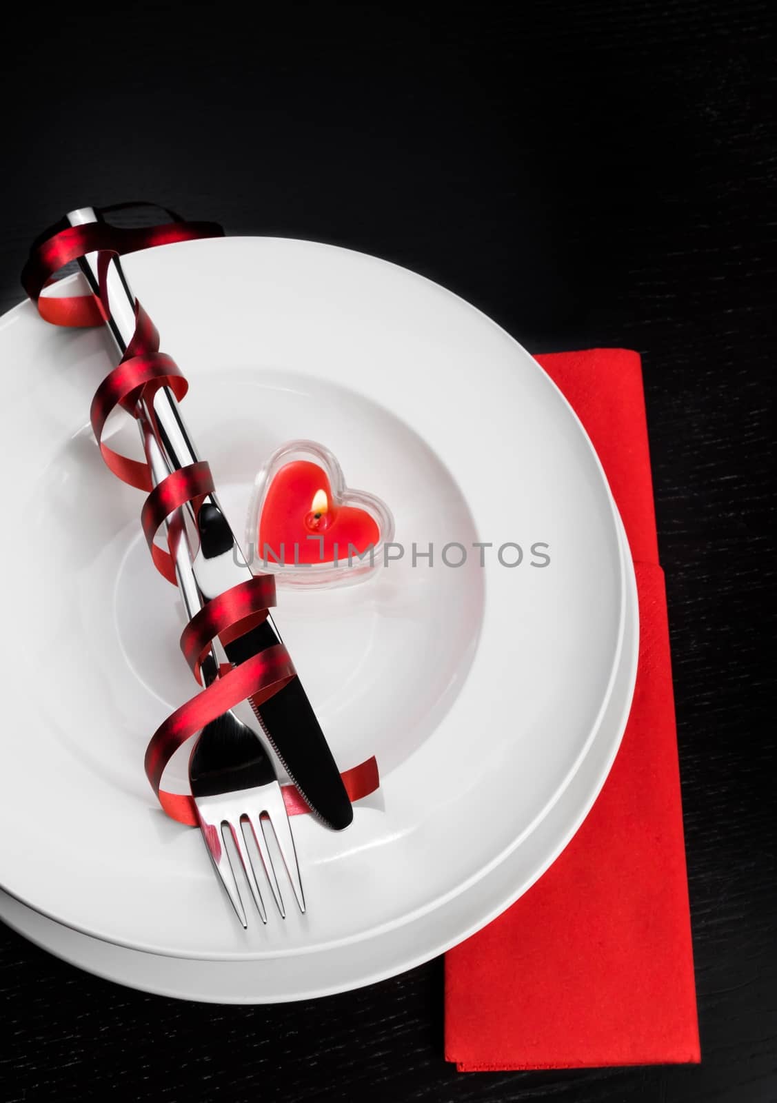 Valentine day dinner with table setting in red and elegant heart ornaments by donfiore