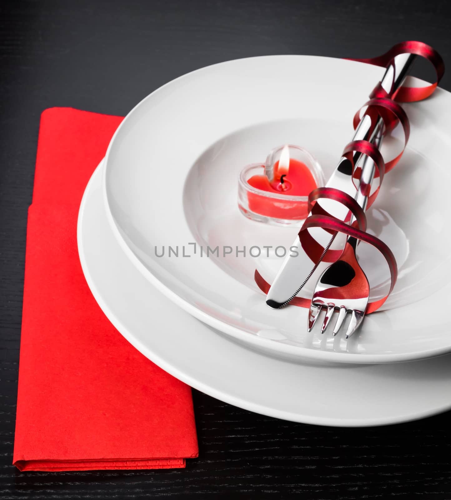 Valentine day dinner with table setting in red and elegant heart ornaments by donfiore