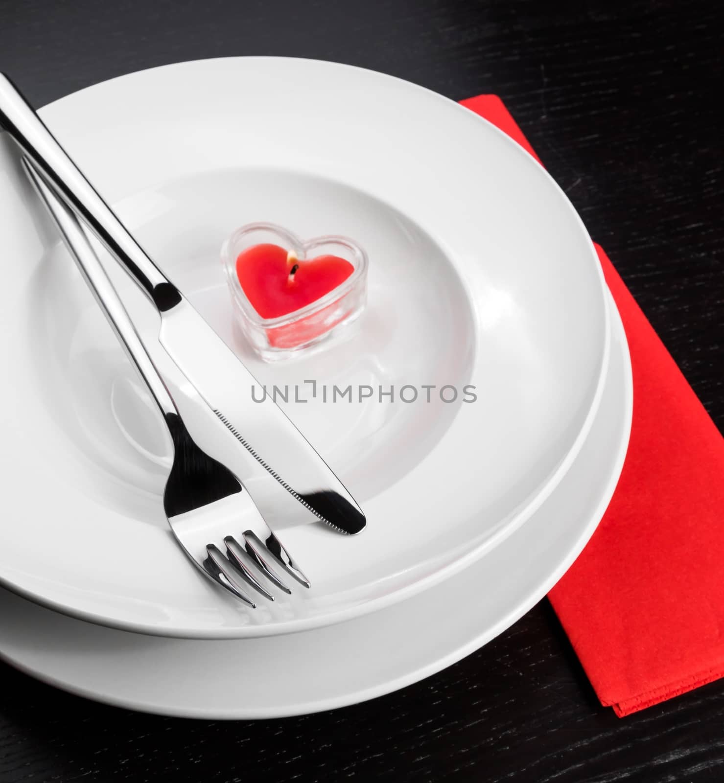 Valentine day dinner with table setting in red and elegant heart ornaments by donfiore