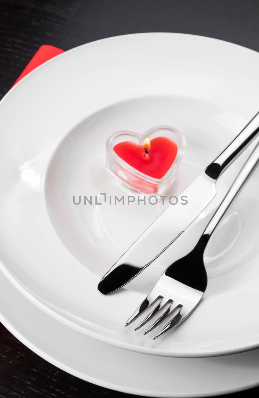 Valentine day dinner with table setting in red and elegant heart ornaments by donfiore