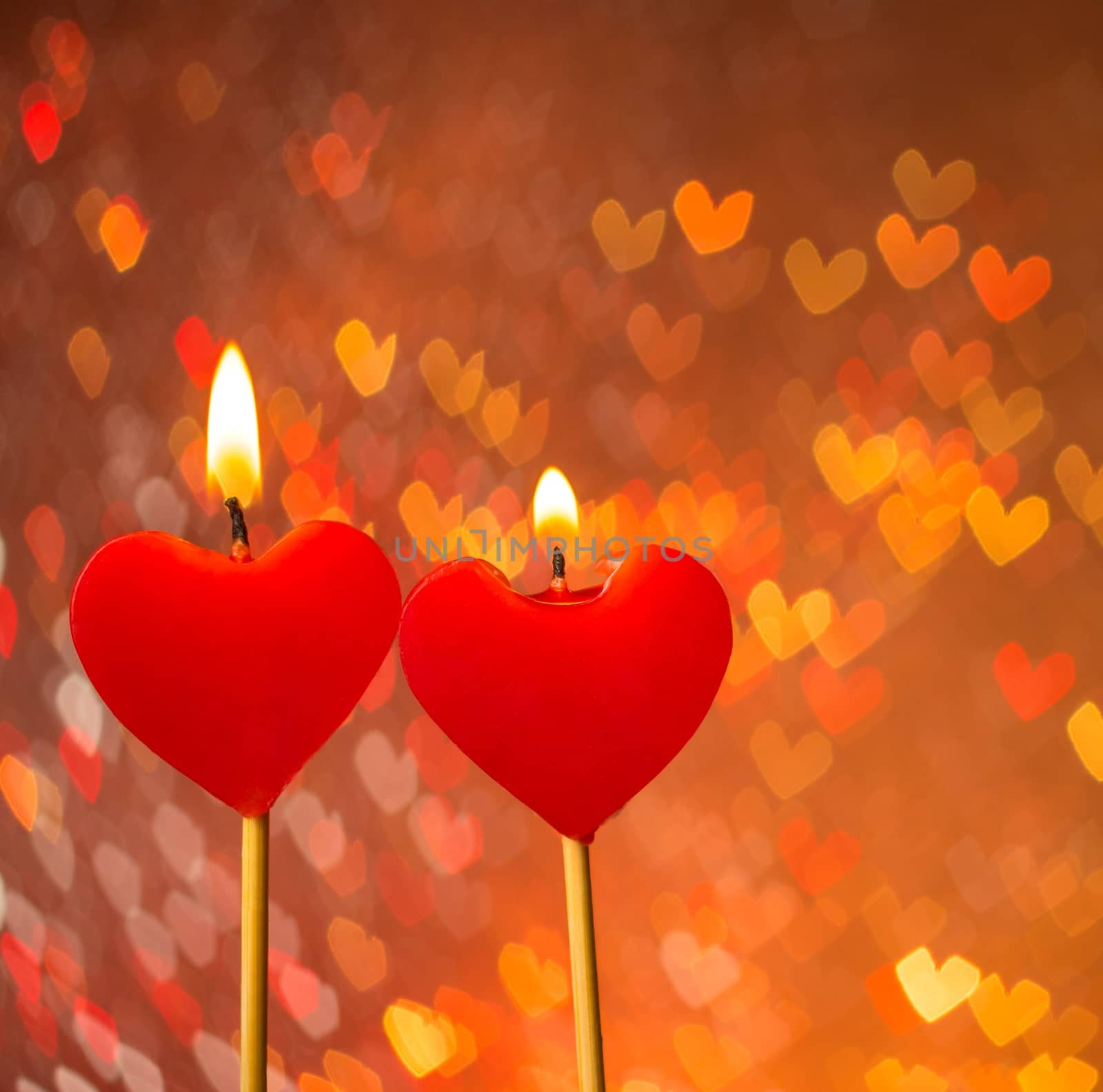 red hearts candles on warm hearts bokeh as background, valentine day and love concept