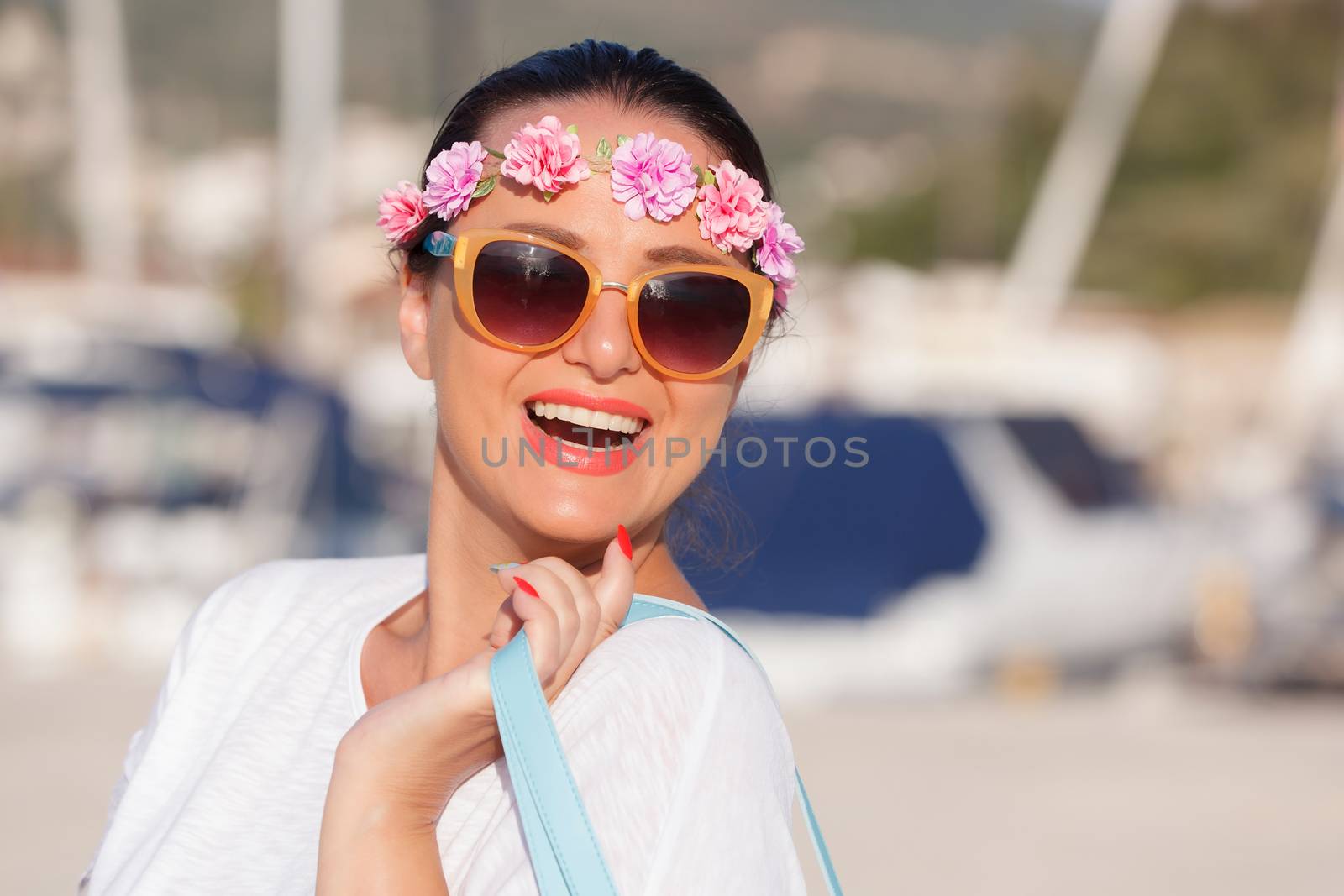 Happy woman walking with bag and enjoying sunny day at marina