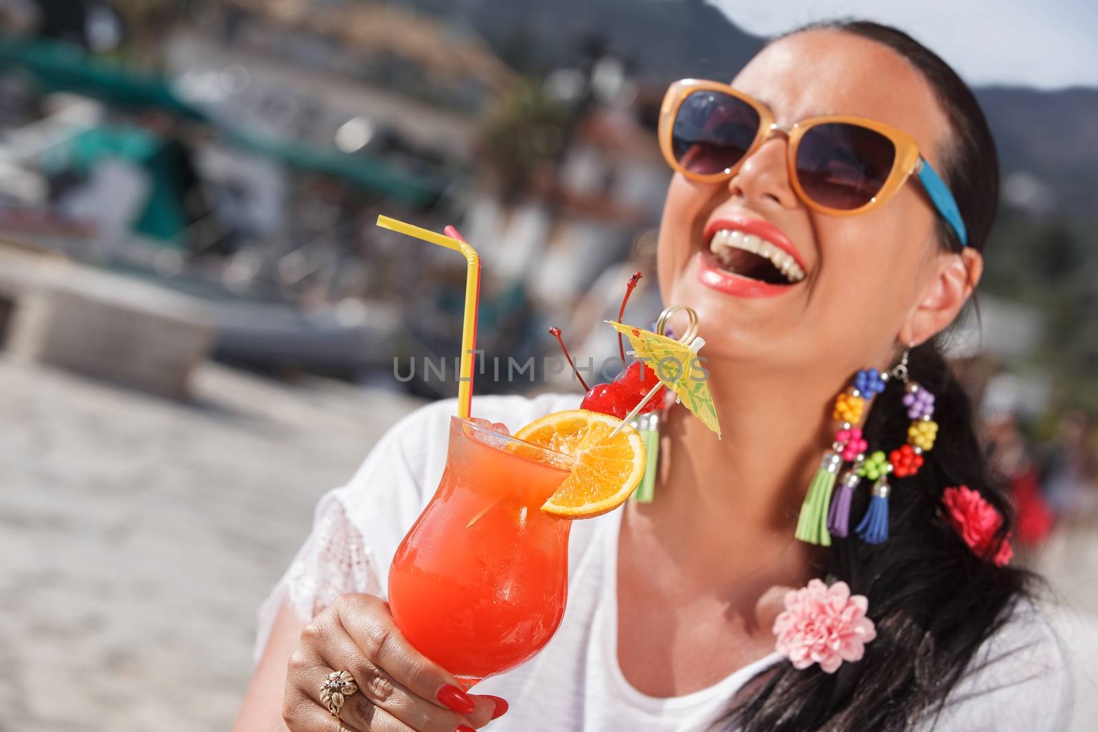 Happy young woman holding a glass of cocktail by Slast20