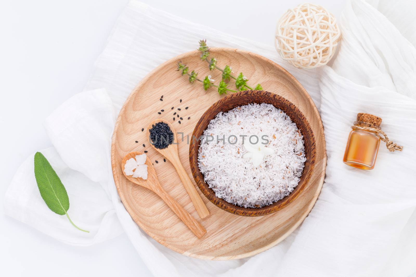 Raw coconut and coconut essential oils  with sea salt and herbs natural spa Ingredients for scrub and skin care isolate on white background.