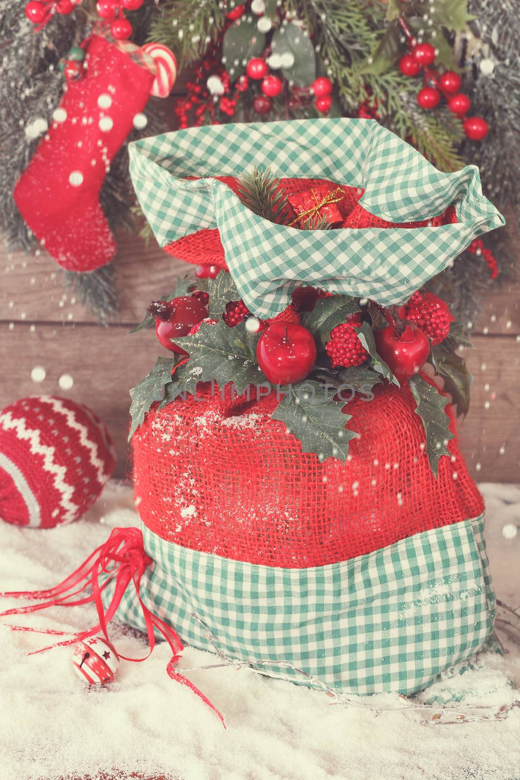 Christmas gift sack tied with ribbon, berries and holly leaves. Macro, selective focus Done with vintage retro filter
