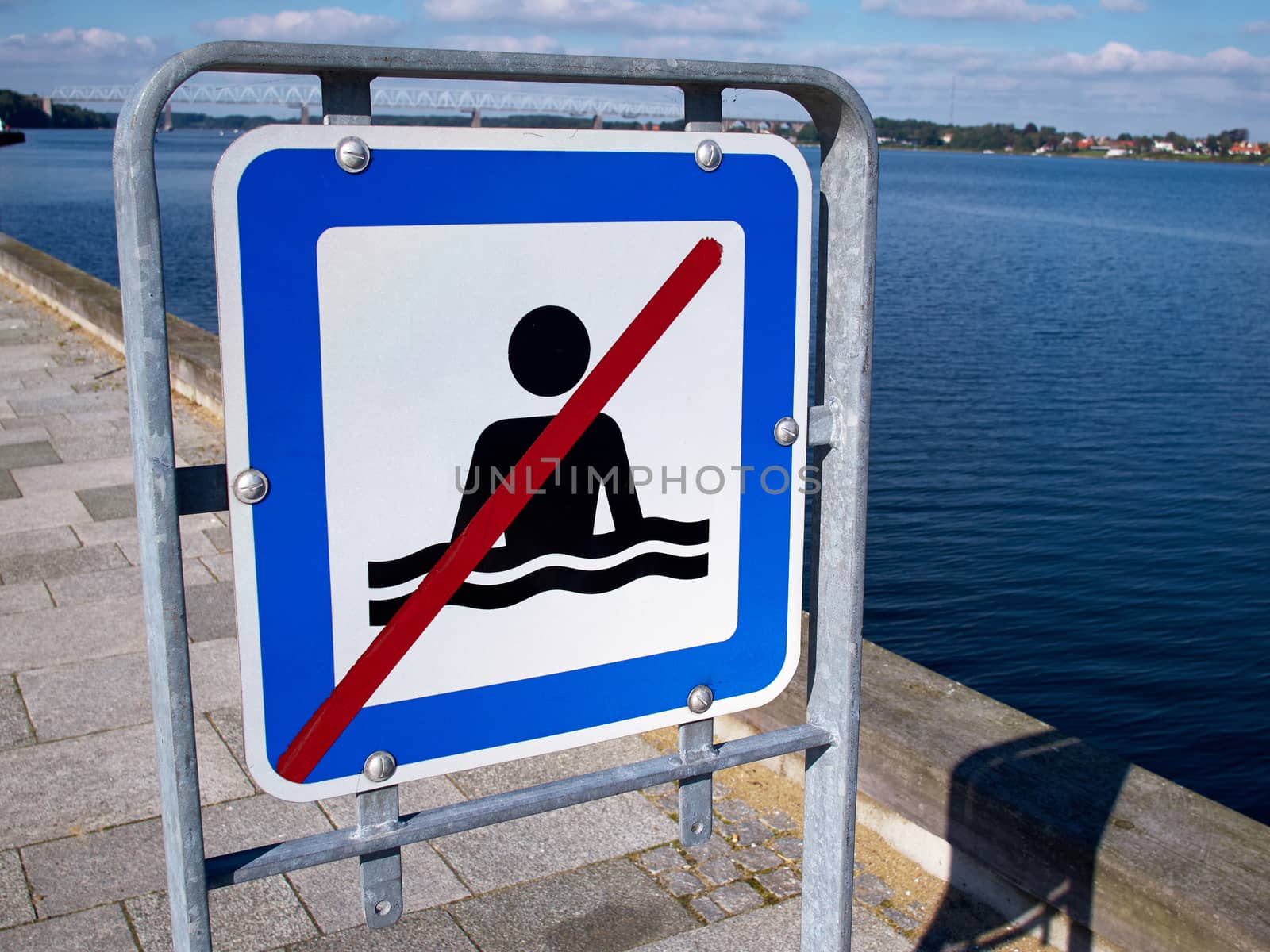 No swimming danger warning sign by the beach ocean  