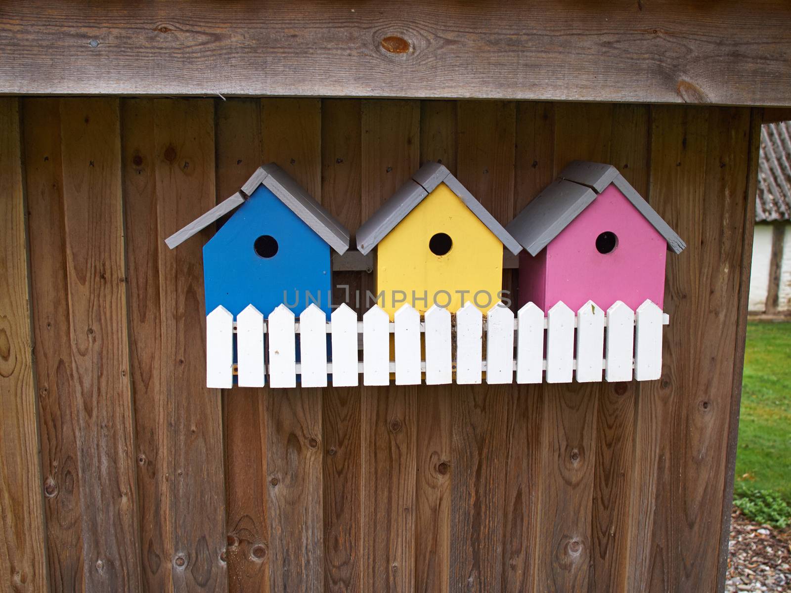 Colorful creative wooden nesting boxes birdhouse hanged on a wall in backyard