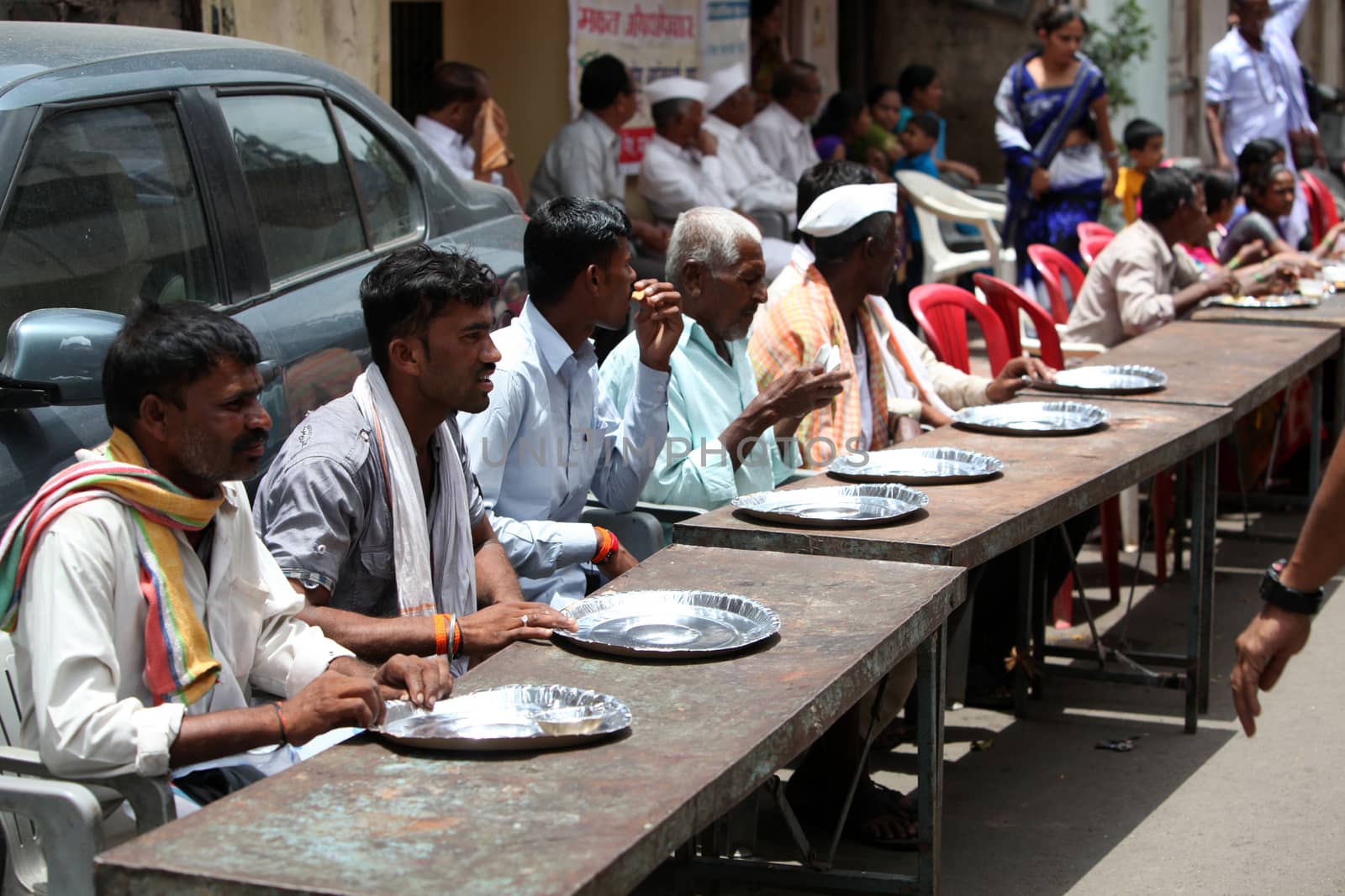 Pune, India - July 11, 2015: Indian pilgrims sitting on table on by thefinalmiracle