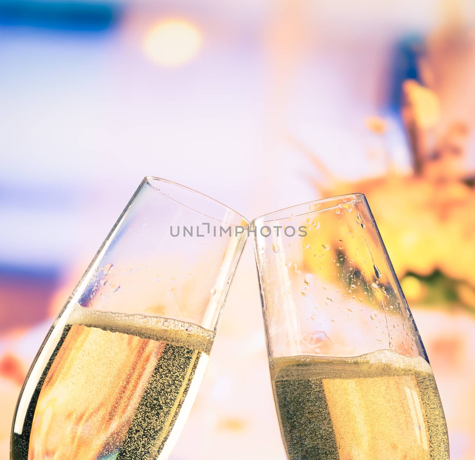 champagne flutes with golden bubbles on flowers background, wedding and valentine day concept by donfiore