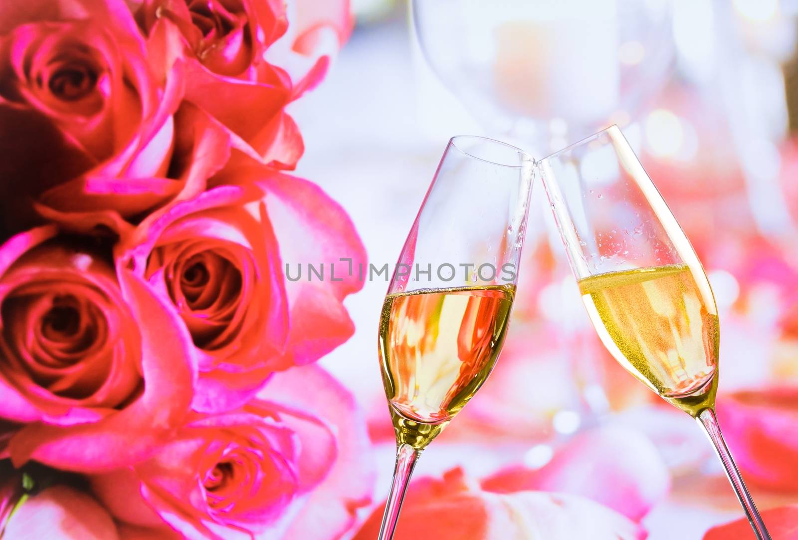 champagne flutes with golden bubbles make cheers on wedding roses flowers background