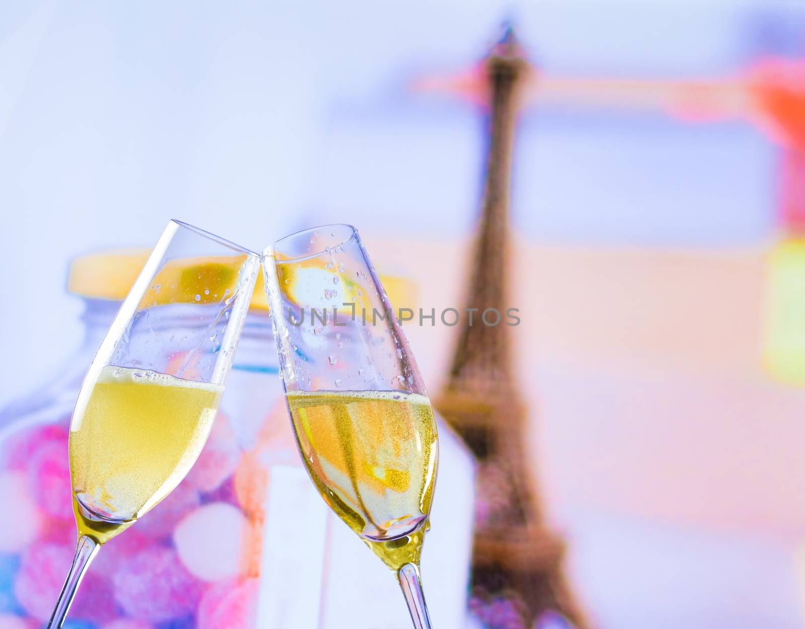 a pair of champagne flutes with golden bubbles make cheers on blur tower Eiffel background valentine day and love concept