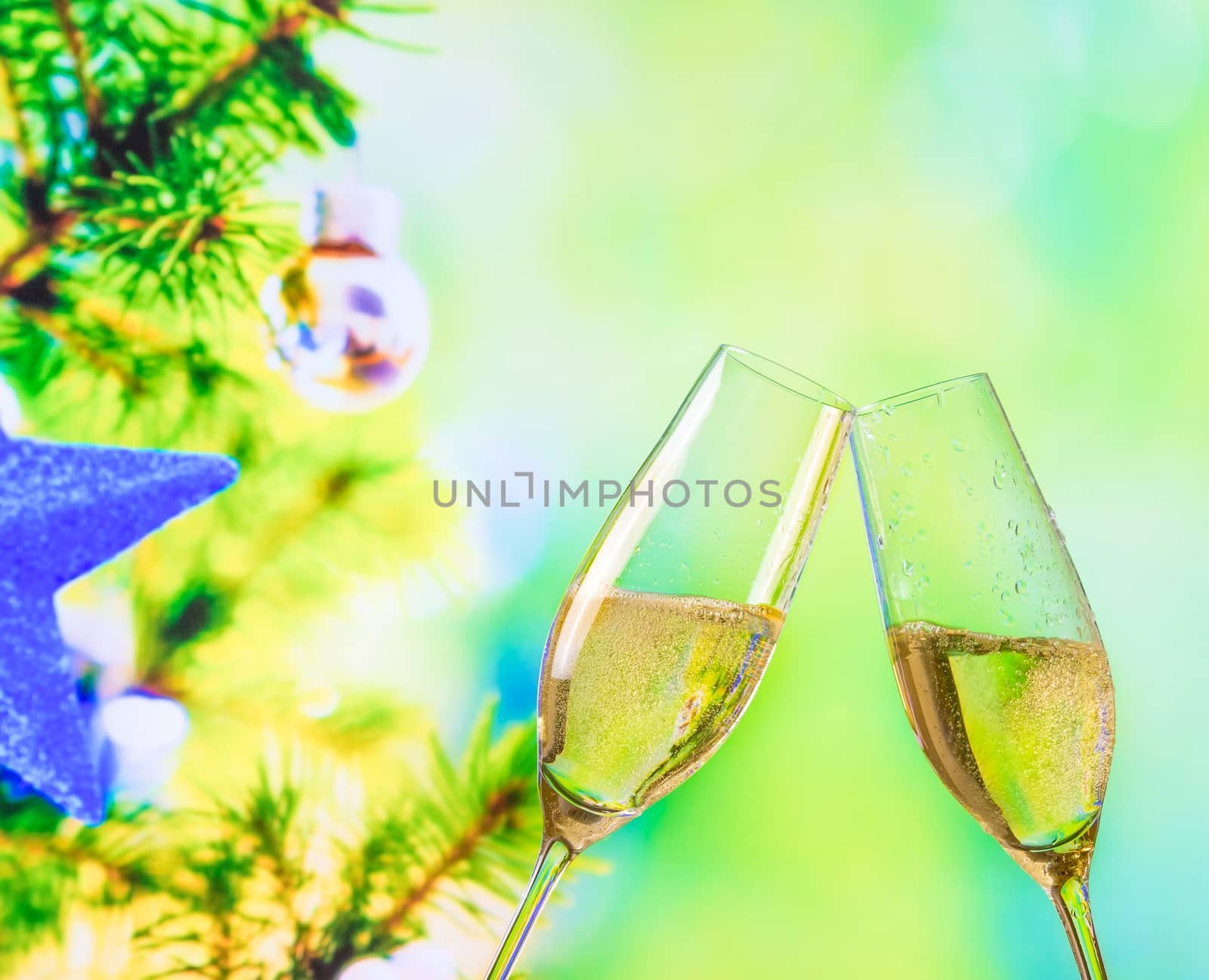 champagne flutes with golden bubbles on christmas tree decoration background by donfiore