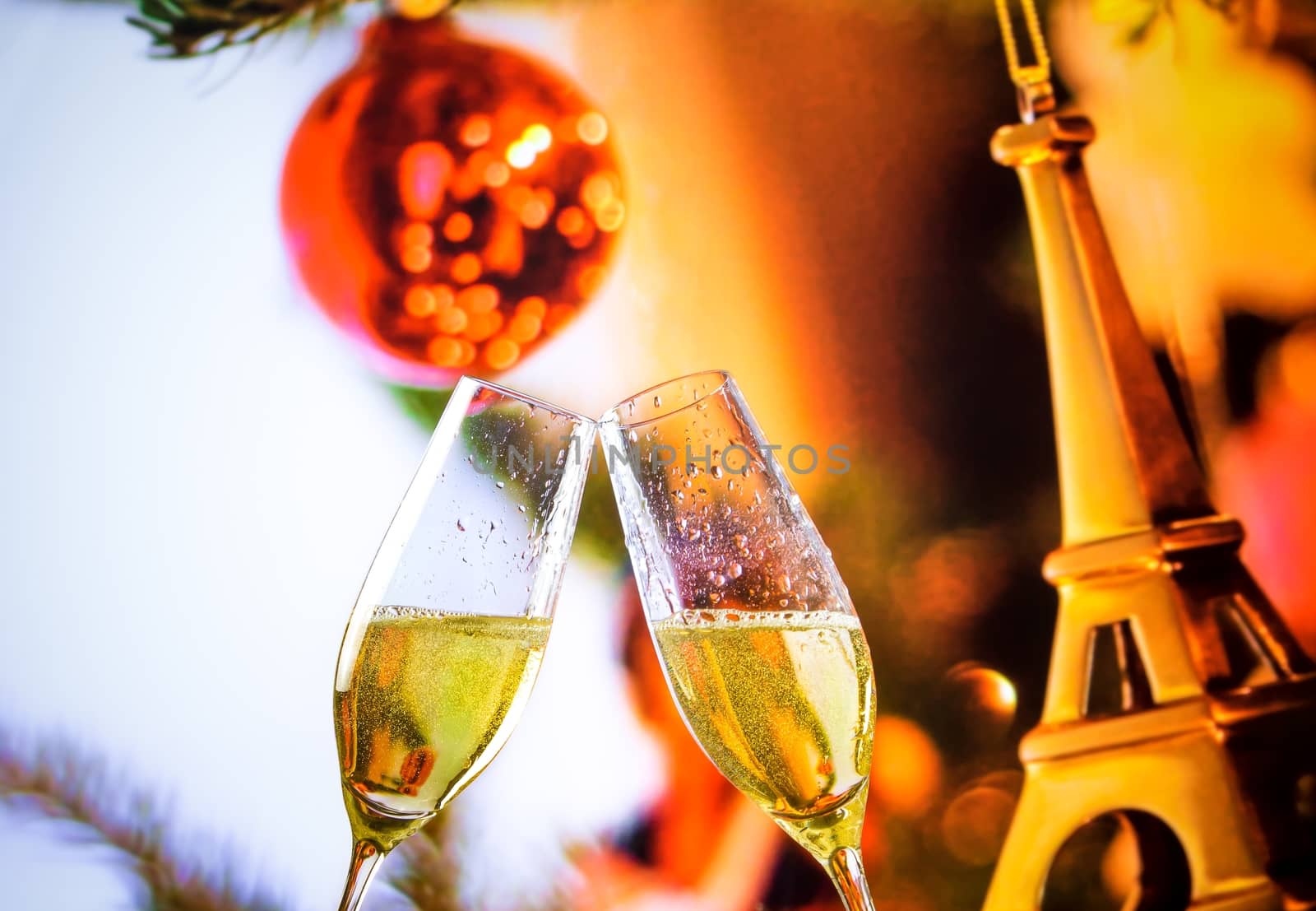 champagne flutes with golden bubbles on christmas eiffel decoration background by donfiore