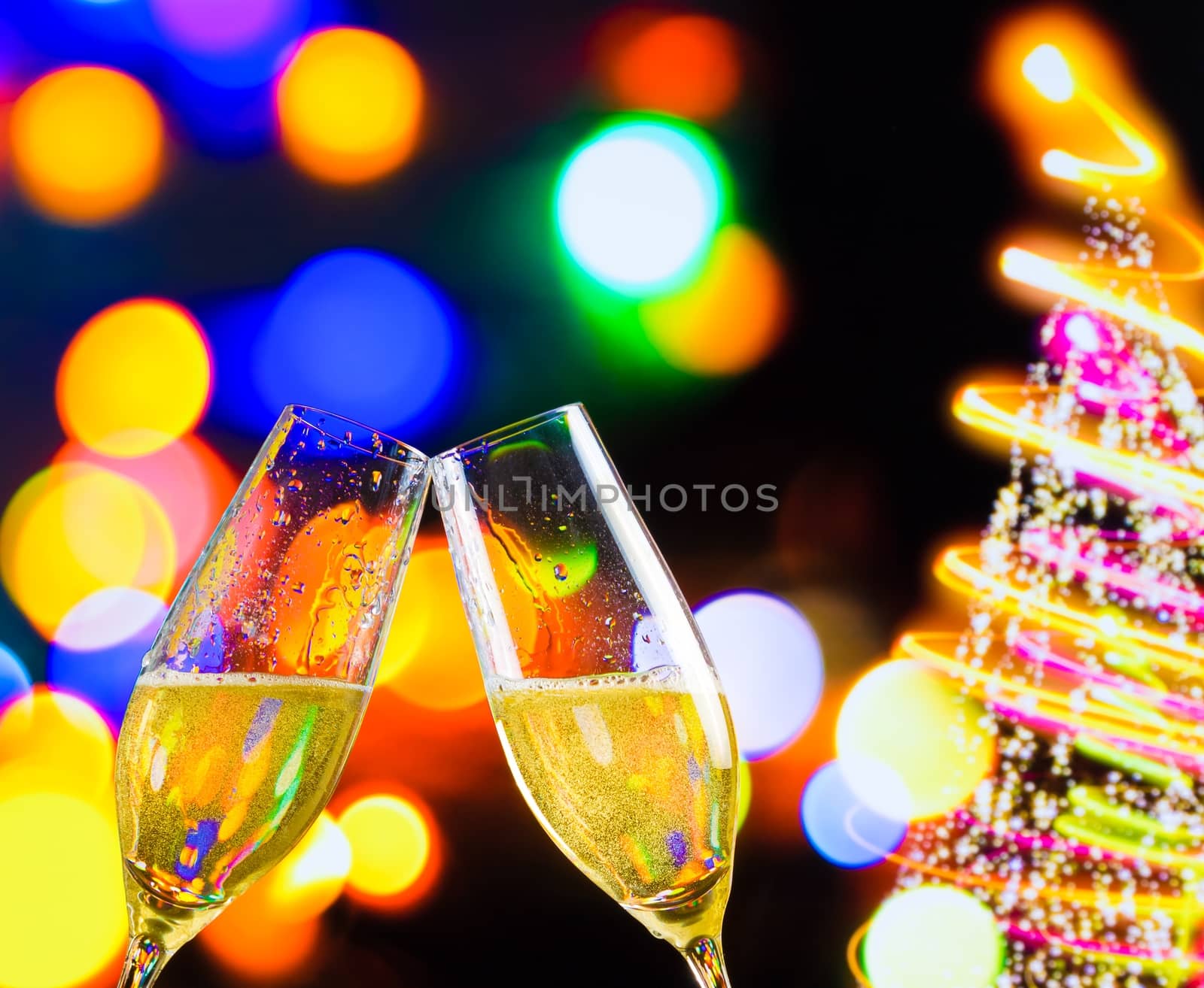 champagne flutes with golden bubbles make cheers on christmas lights bokeh decoration background, christmas atmosphere