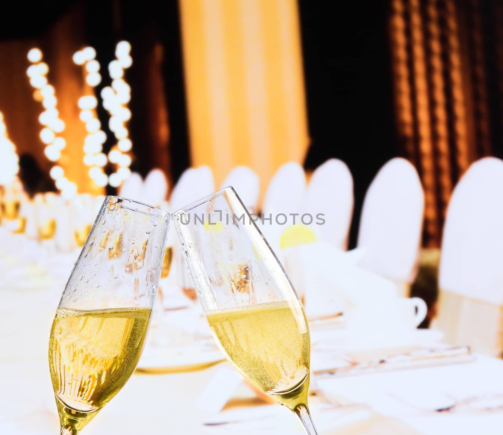 champagne flutes with golden bubbles on christmas table decoration background by donfiore