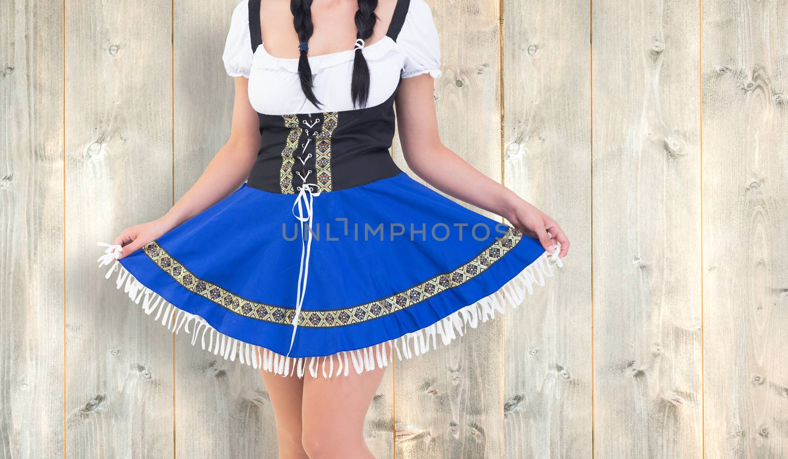 Oktoberfest girl spreading her skirt against pale wooden planks