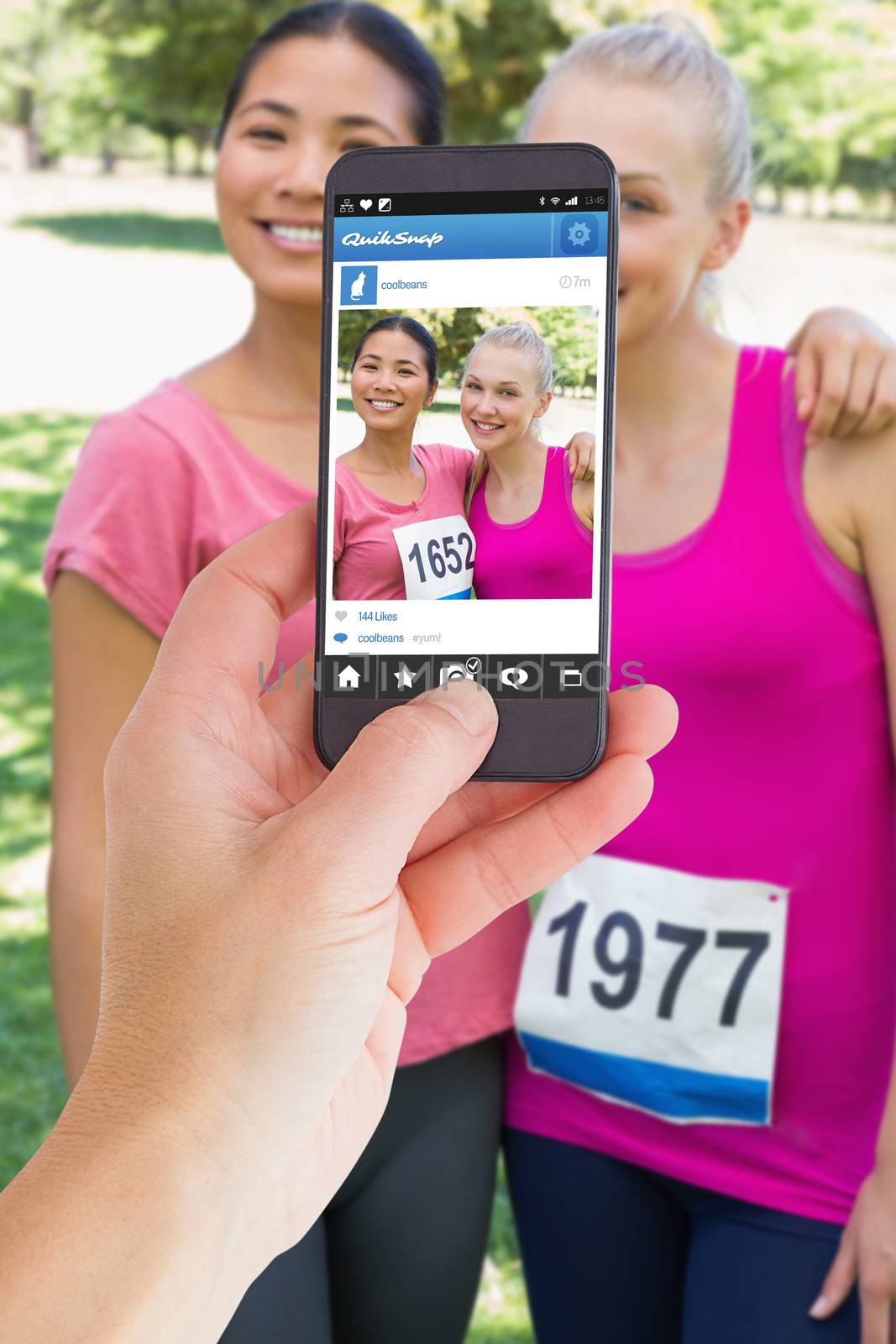 Female hand holding a smartphone against photo sharing app