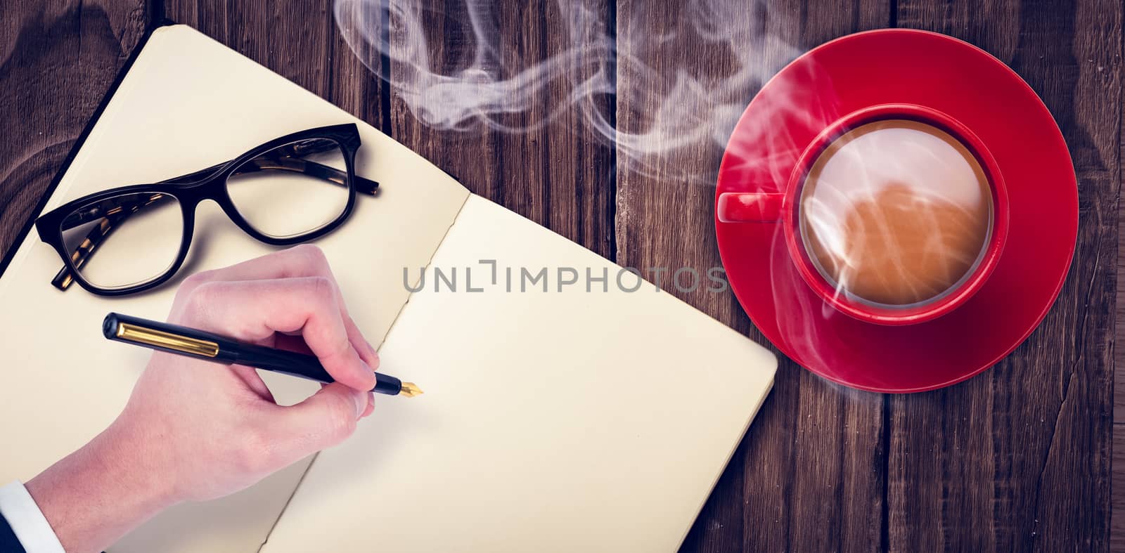 Overhead view of hot tea by hand writing on book against wooden table