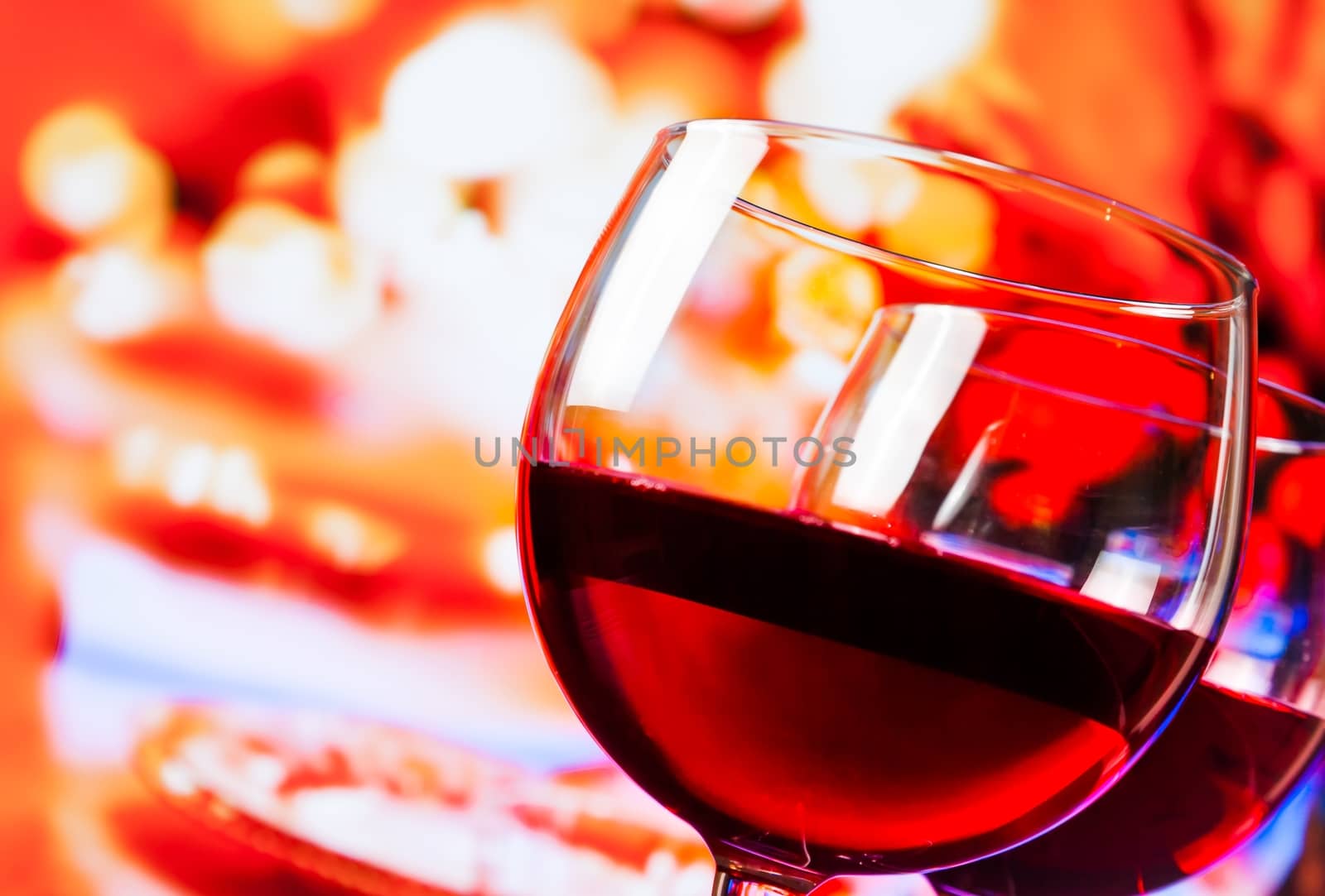 detail of red wine glasses against unfocused restaurant table background, festive and fun concept
