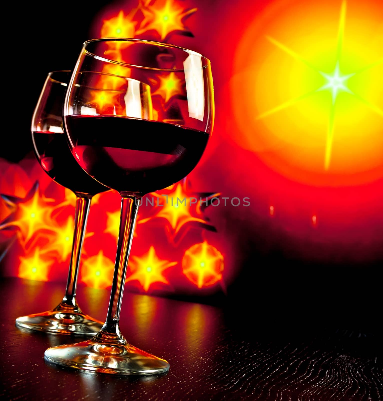 two red wine glass against golden lights tree background by donfiore