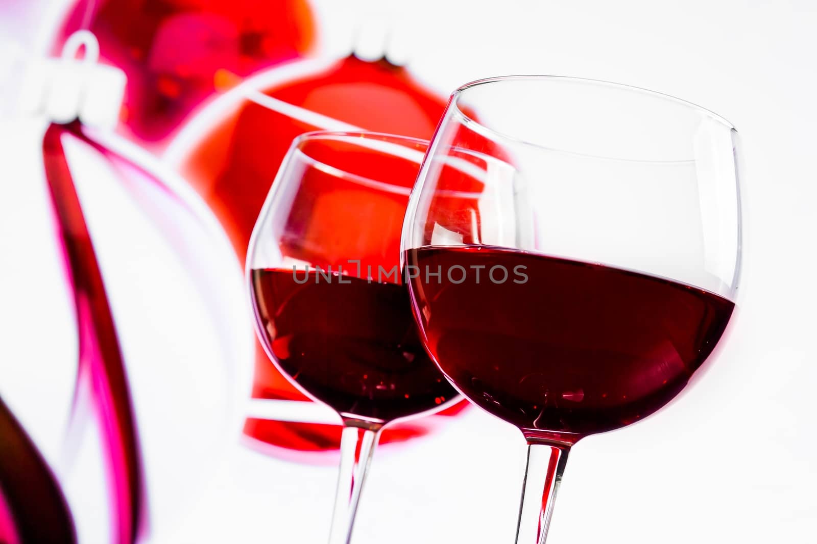 two red wine glasses against christmas decoration background by donfiore