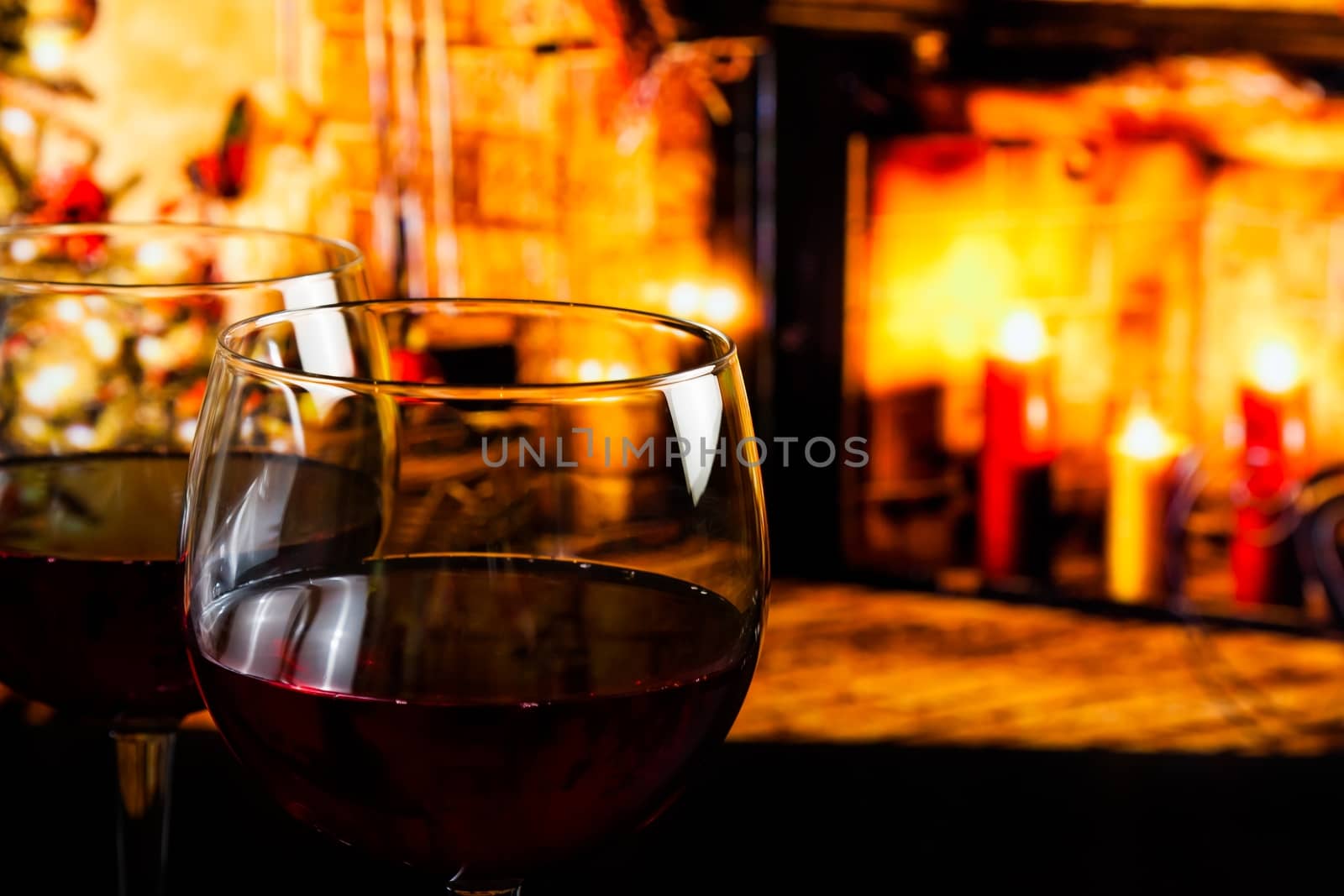 red wine glass against christmas lights decoration background, christmas atmosphere
