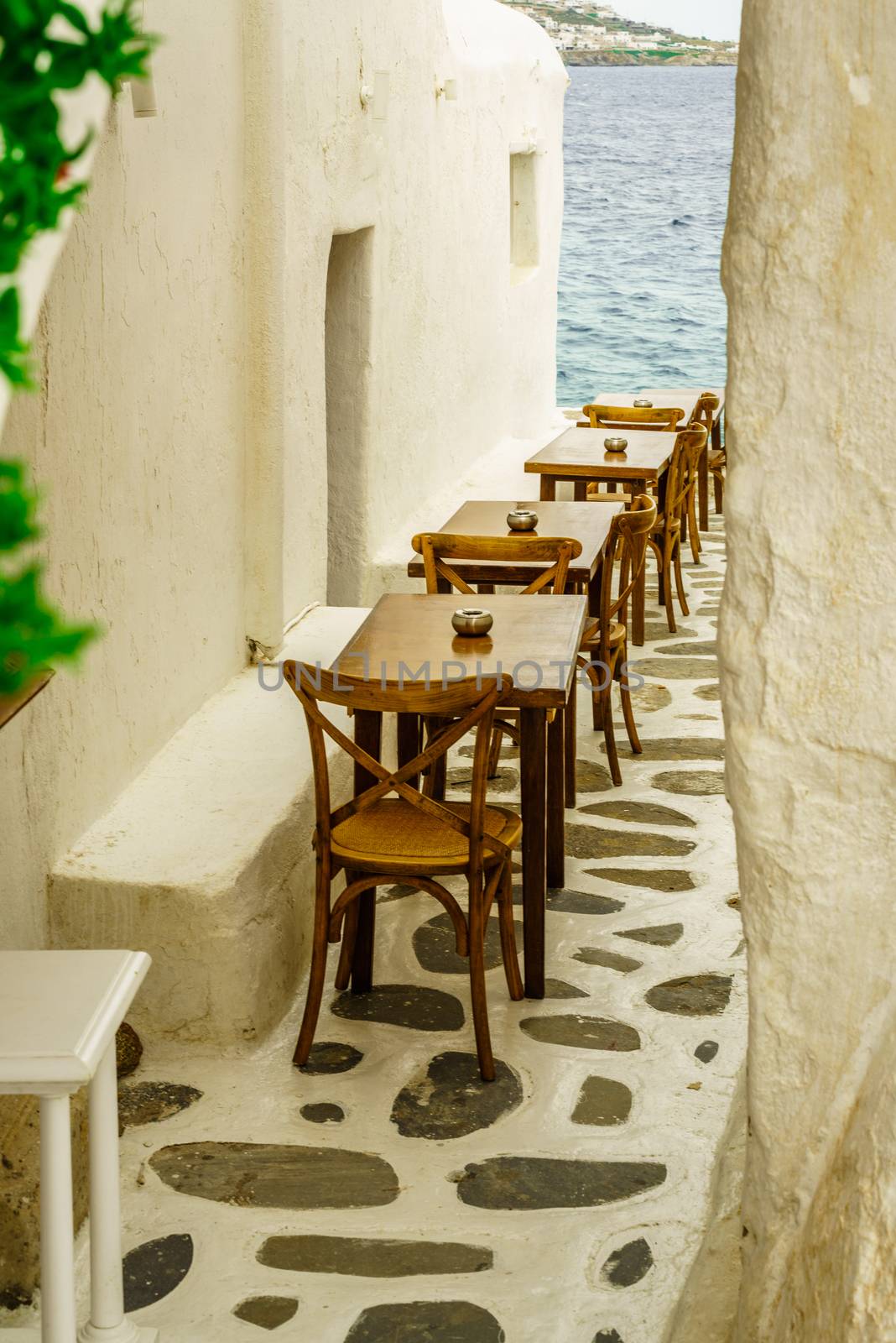 Tiny ally in Greece beckons weary travelers to it's tables wooden.