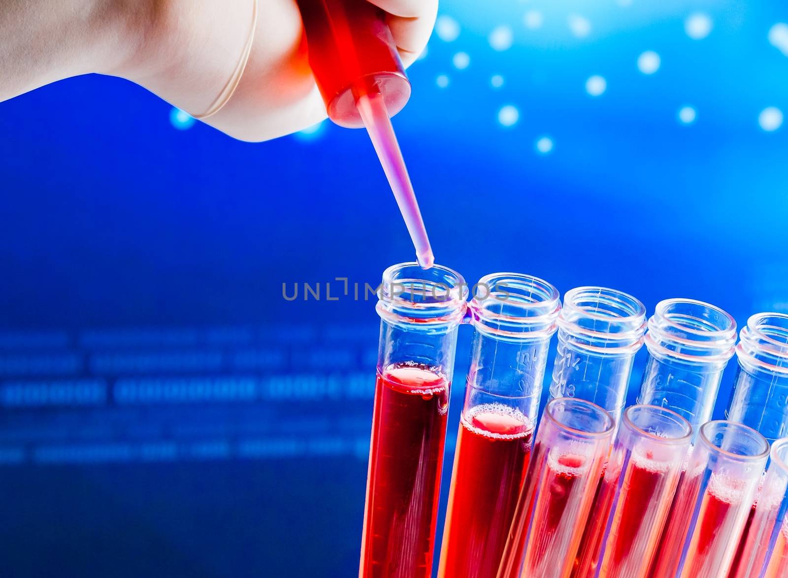 closeup of test tubes with pipette on red liquid on blue light tint background