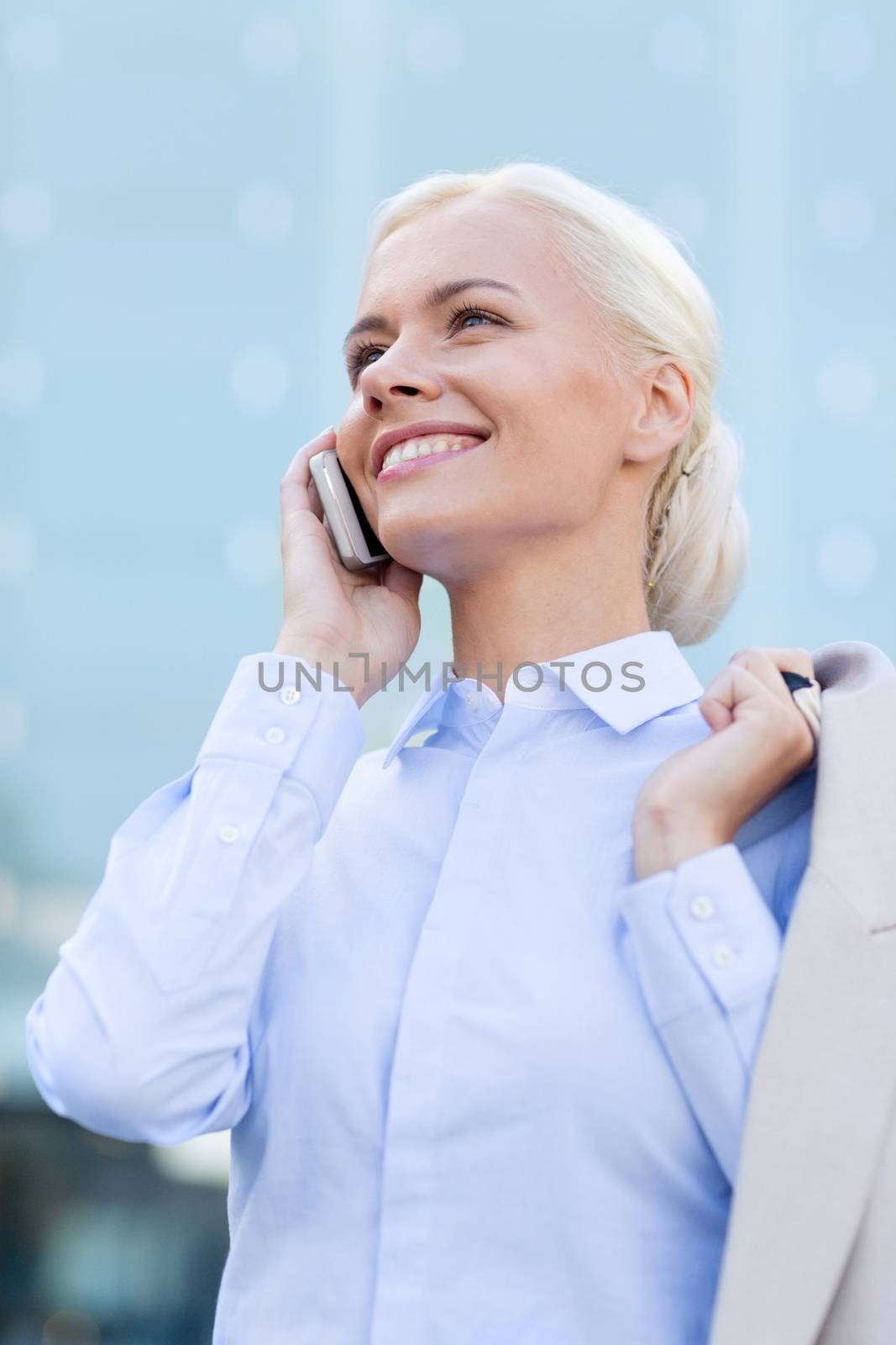 smiling businesswoman with smartphone outdoors by dolgachov