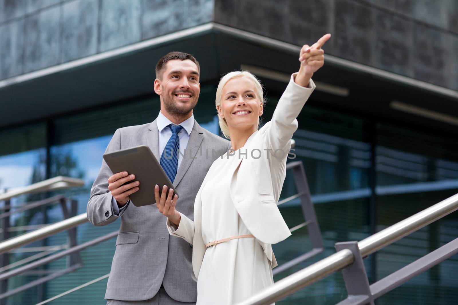 smiling businessmen with tablet pc outdoors by dolgachov