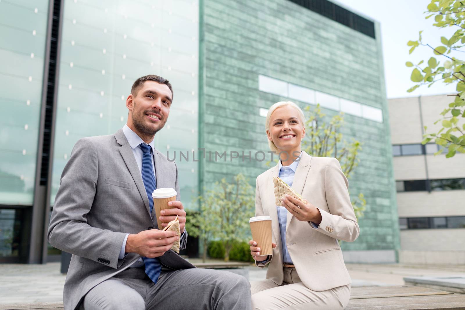 smiling businessmen with paper cups outdoors by dolgachov