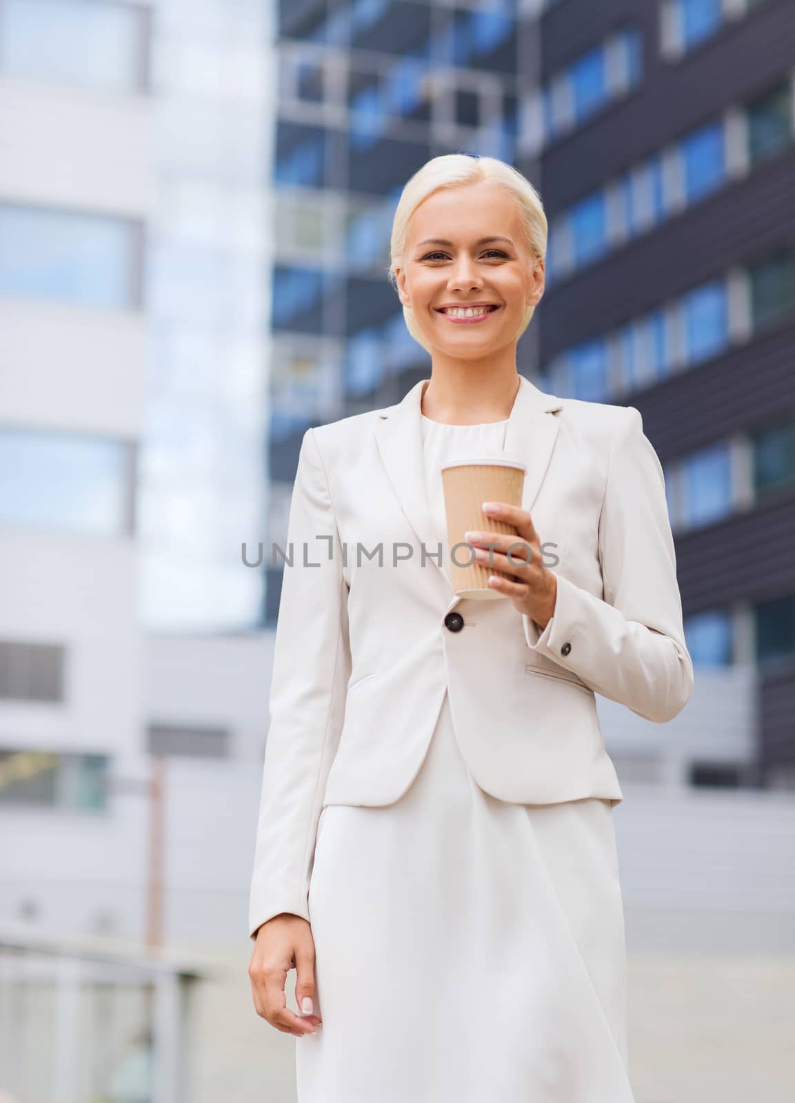 smiling businesswoman with paper cup outdoors by dolgachov