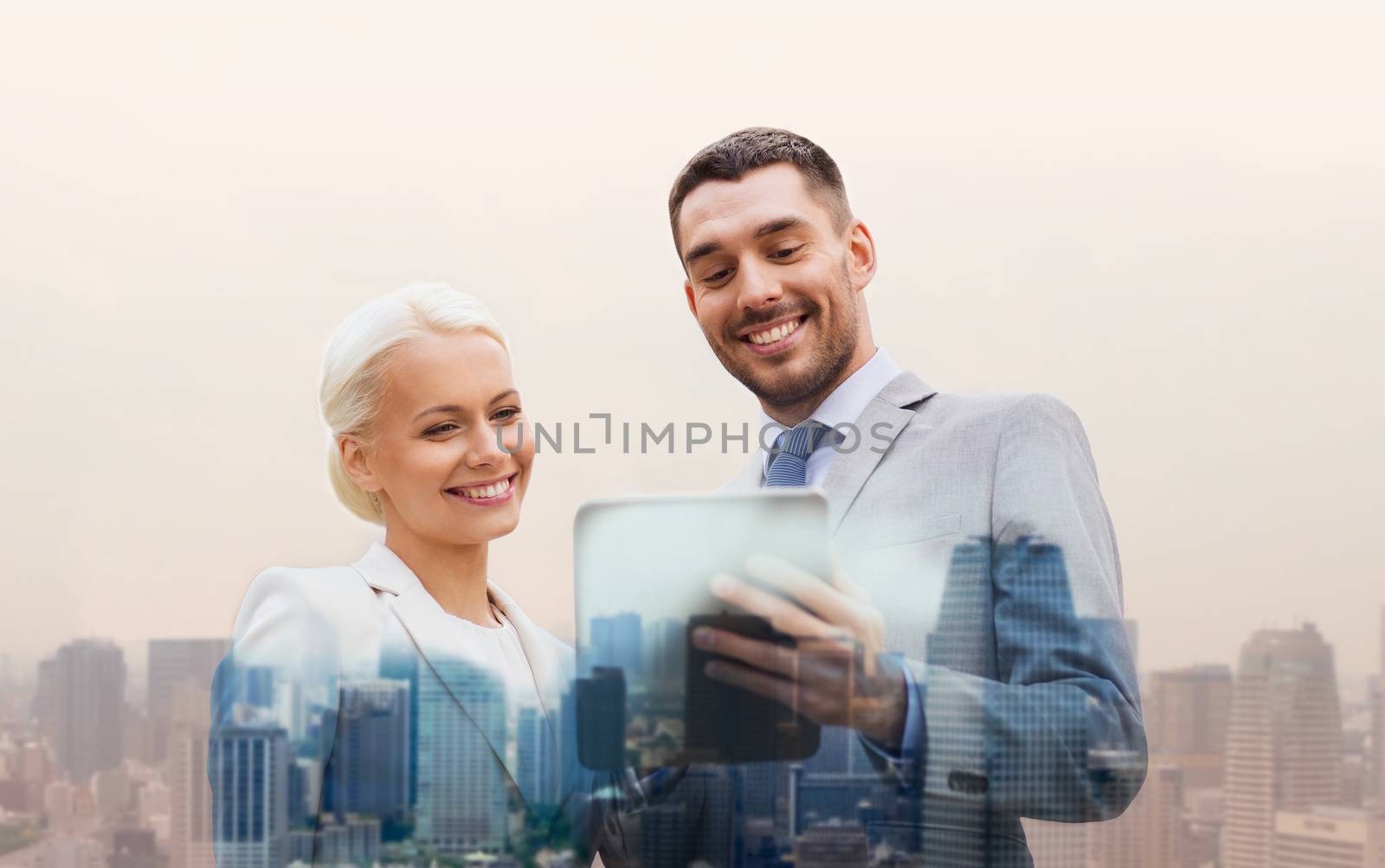 business, partnership, technology and people concept - smiling businessman and businesswoman with tablet pc computer over city background