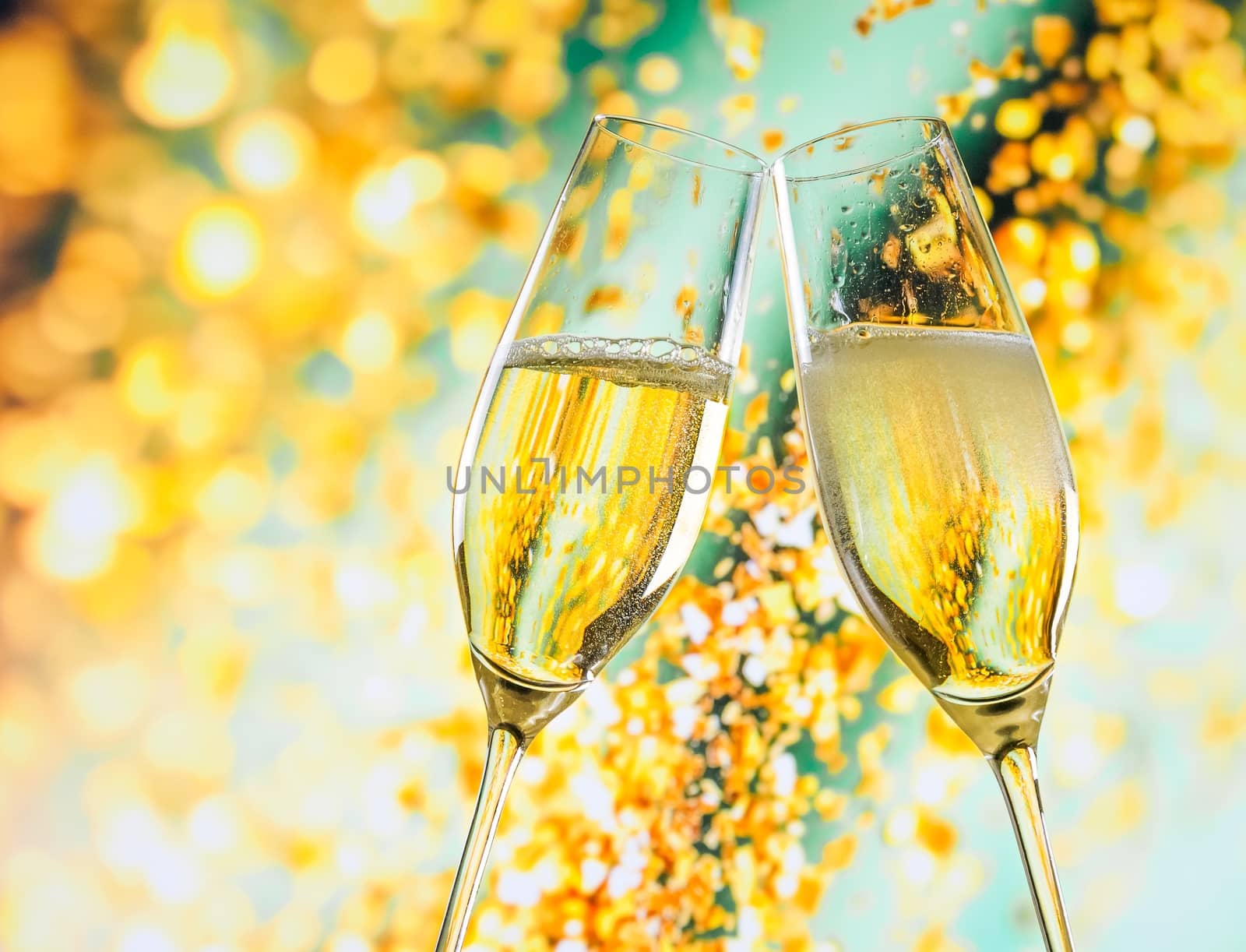 a pair of champagne flutes with golden bubbles on golden light background by donfiore
