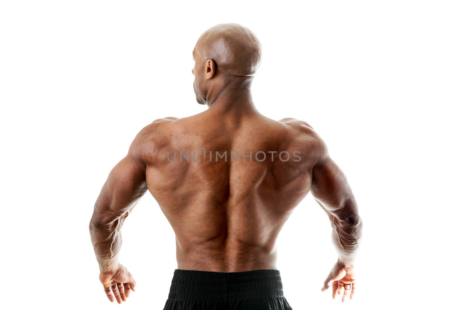 Toned and ripped lean muscle fitness man standing in front of a white background. Shallow depth of field.